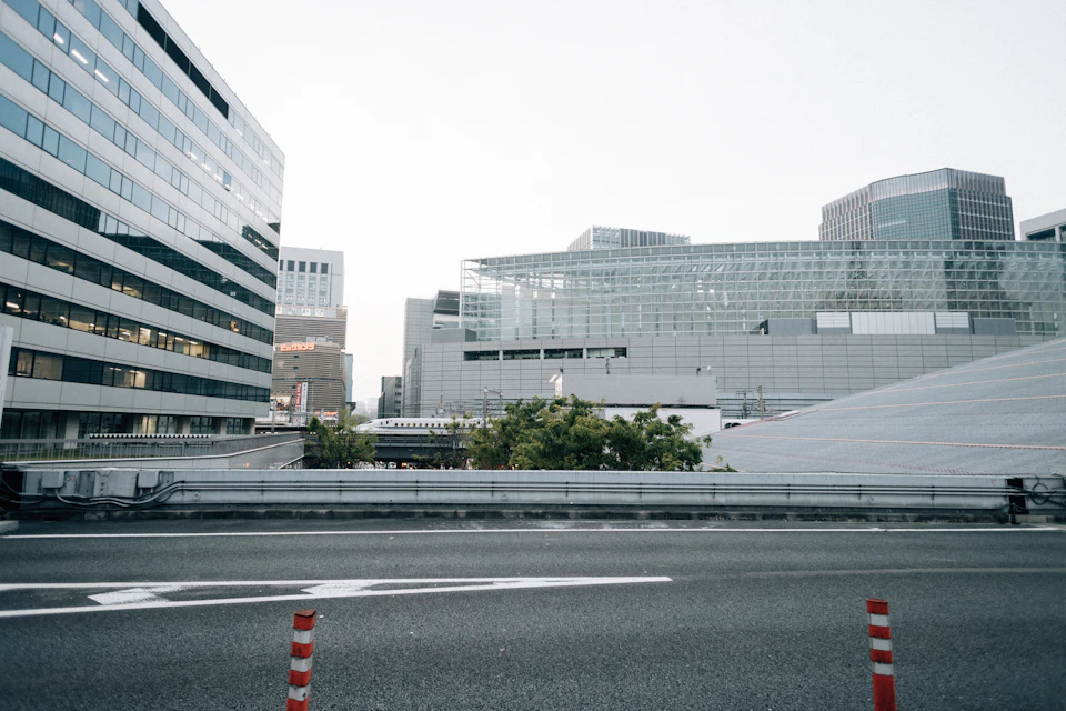 Large glass building stands out against a modern cityscape with overcast sky above