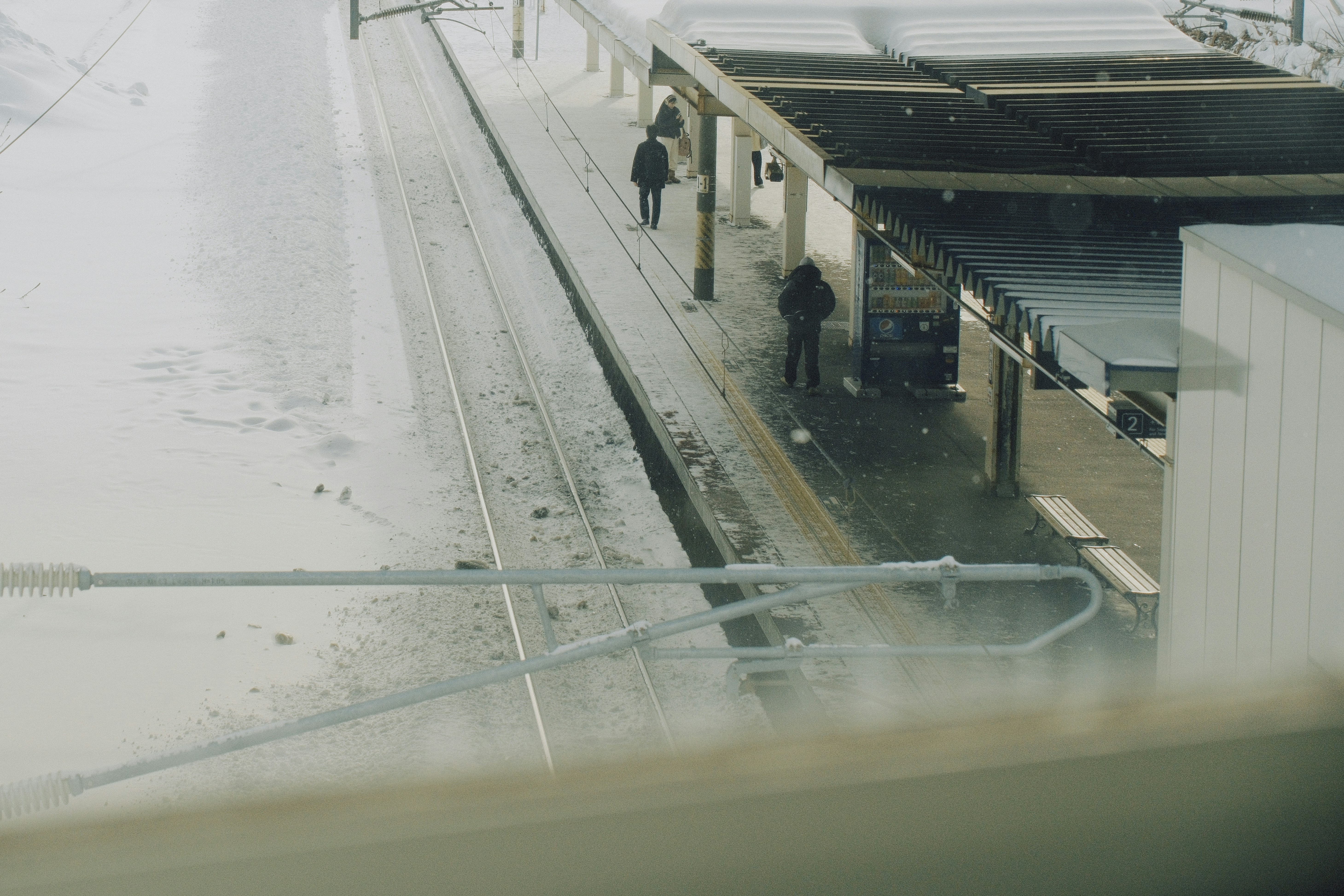 Person walking carefully on an icy platform at a Japanese train station