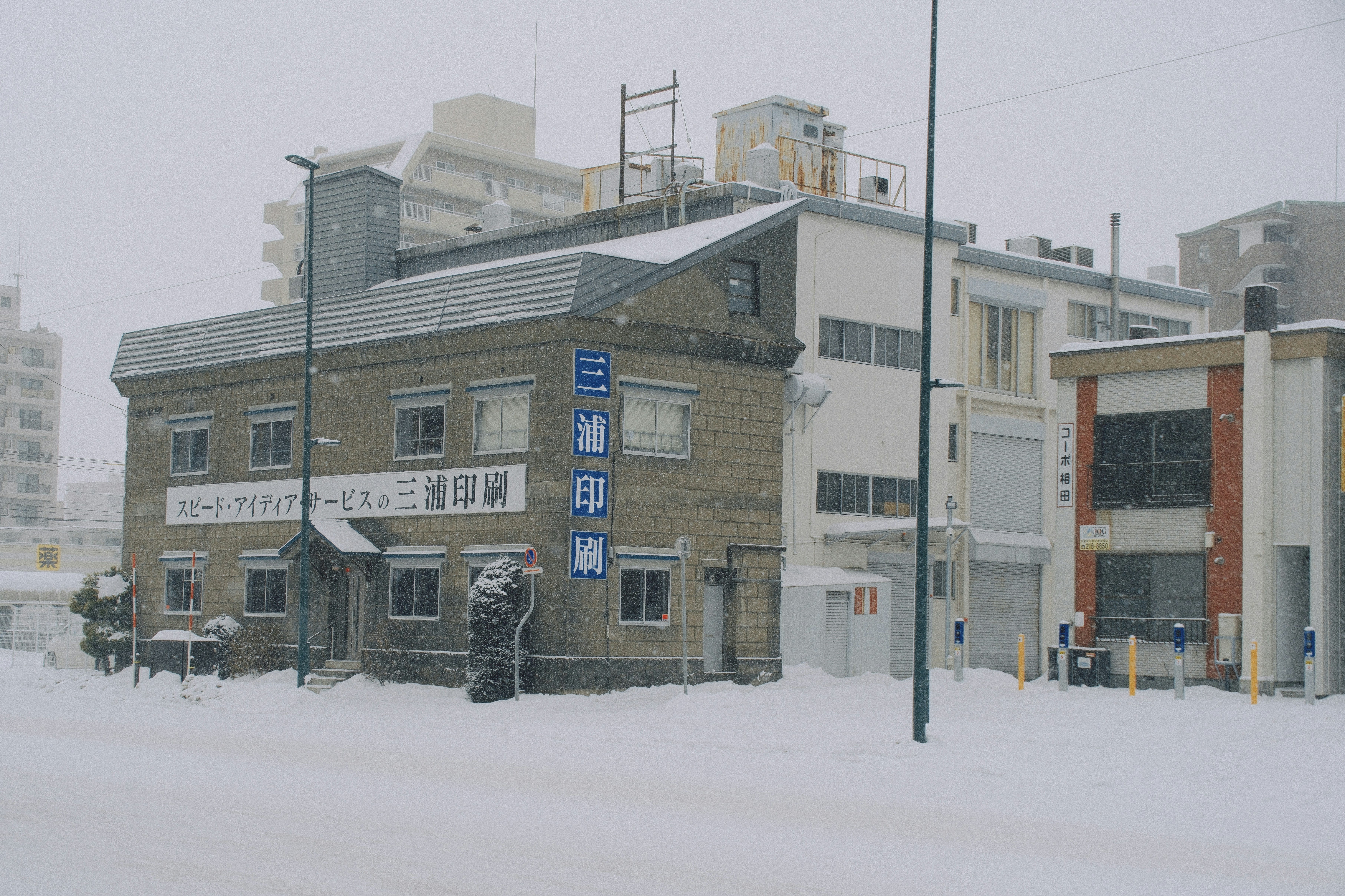 heavy snow in Japanese town, people walking carefully, small hospital sign in background