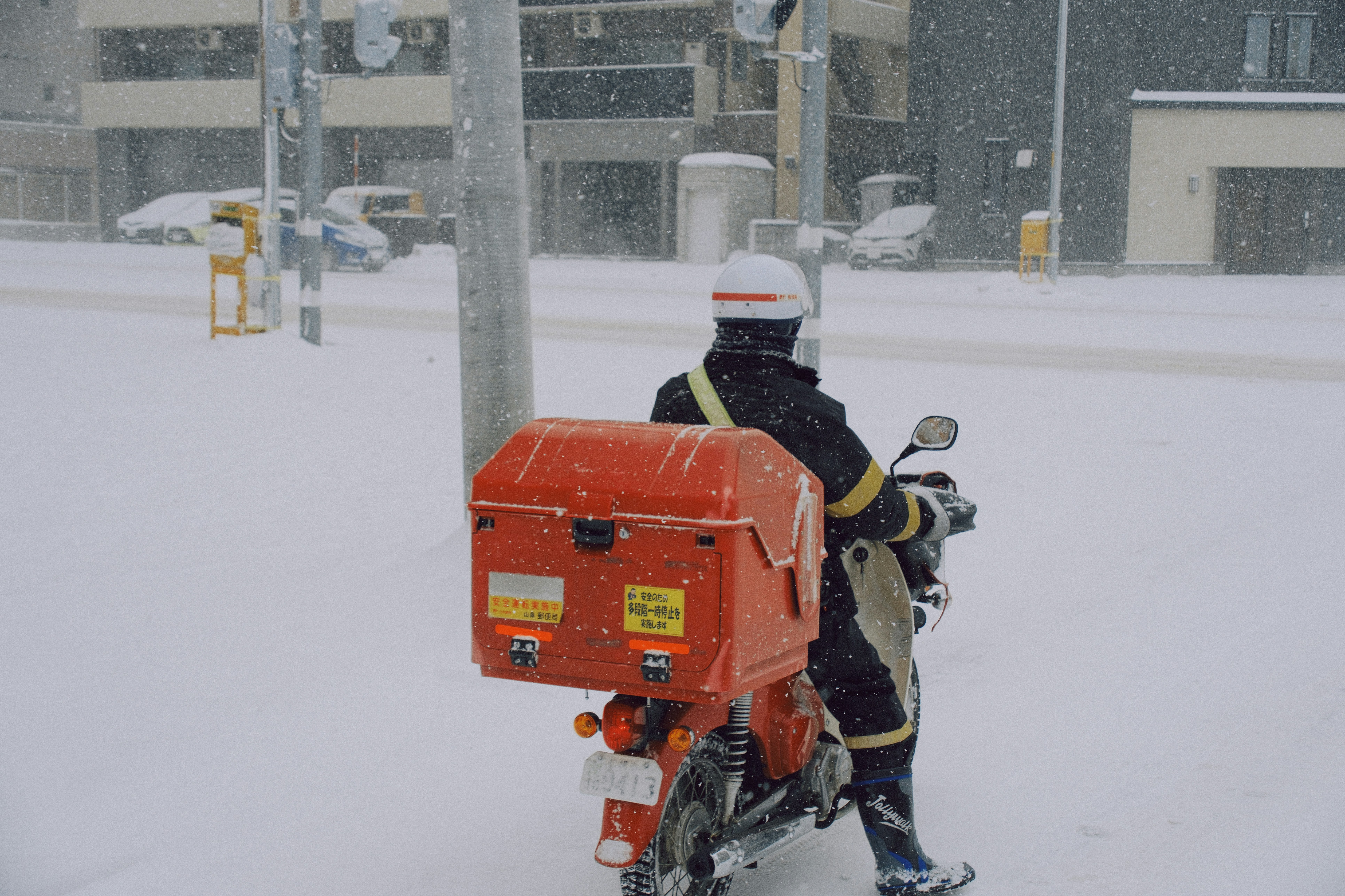 Rescue worker assisting a tourist in heavy snow in Japan