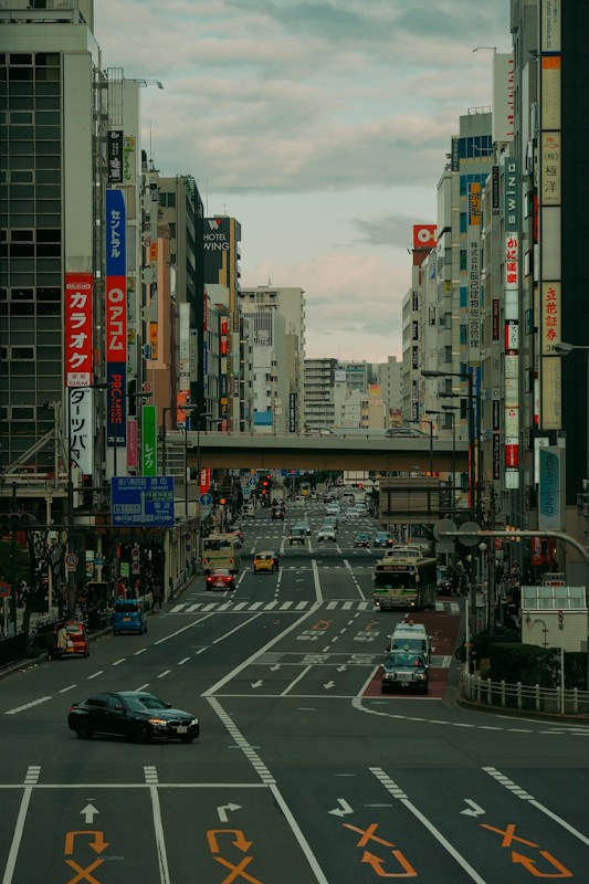 大阪市區的多線道幹道，上方是天橋，路上有公車與計程車