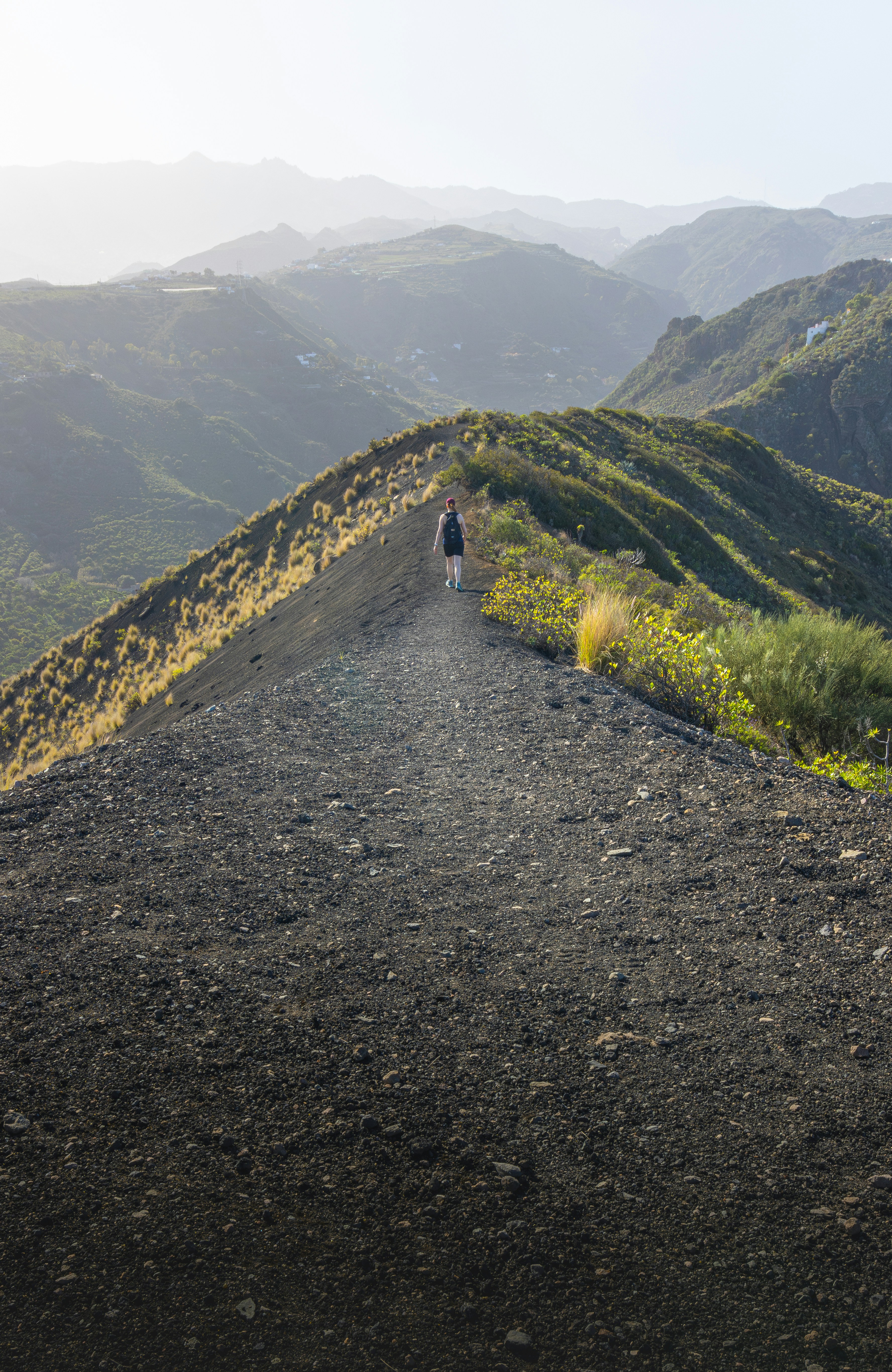 Person walking on a mountain ridge at sunset