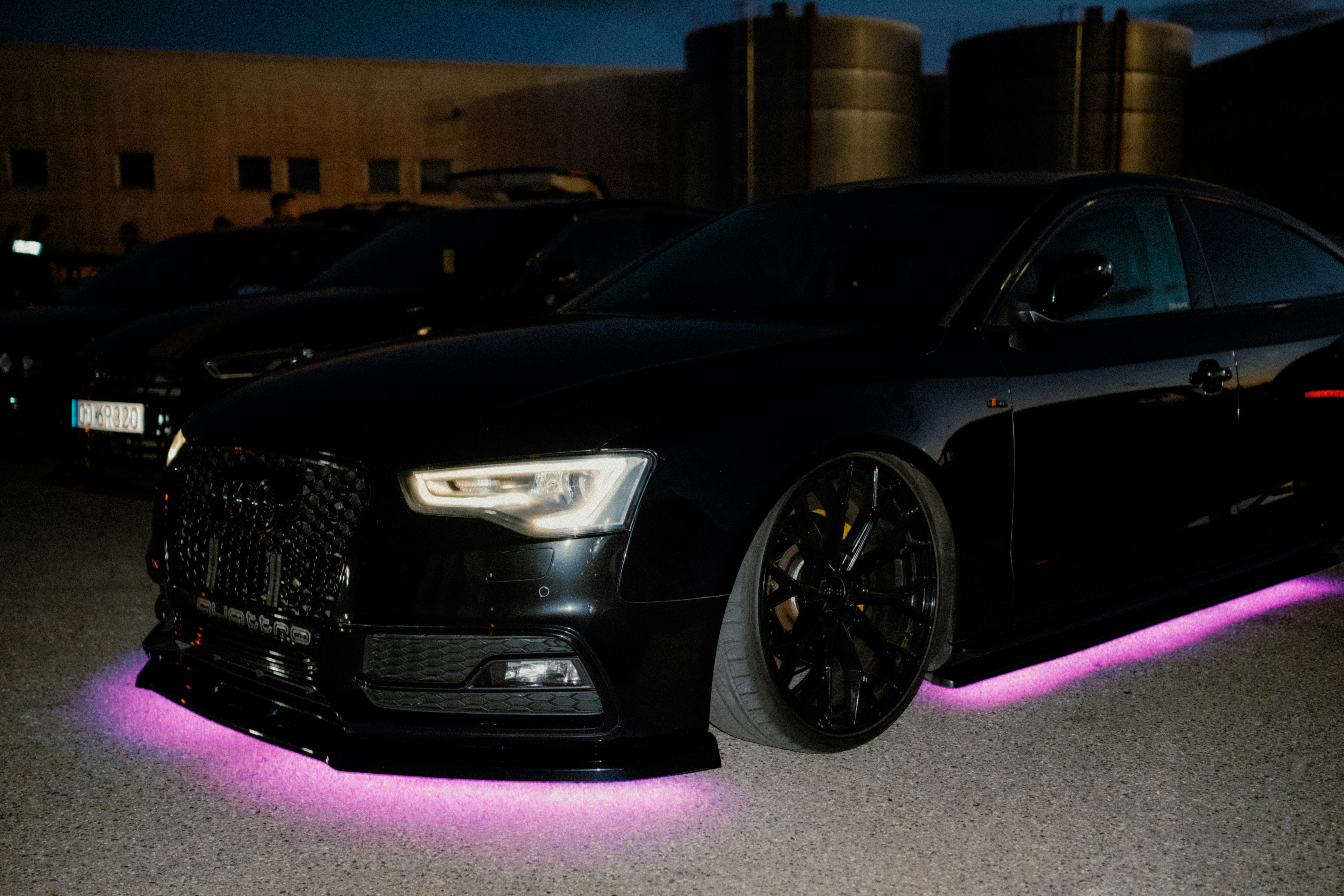 Black car with purple underglow at night