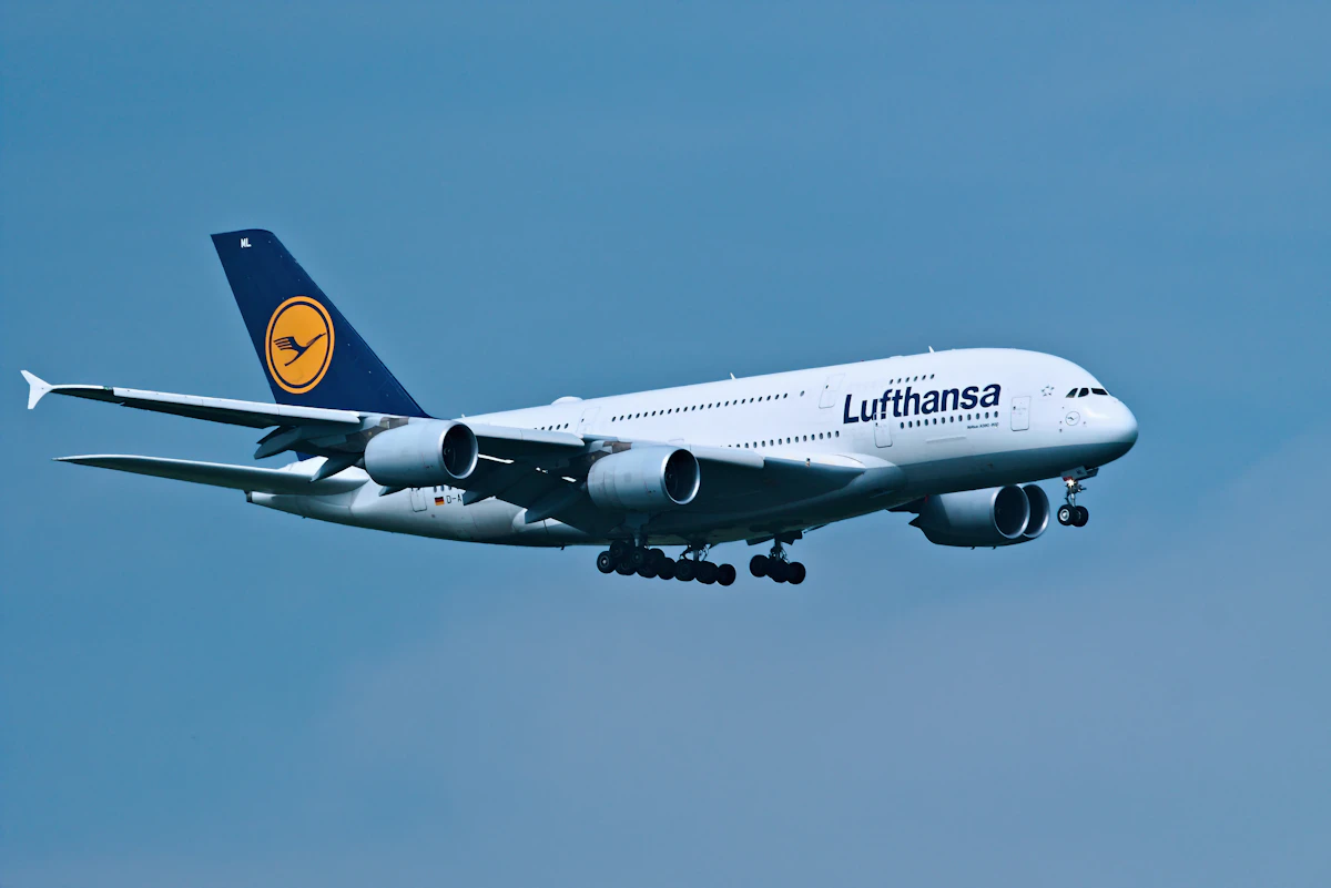 A Lufthansa passenger jet flying in a clear blue sky