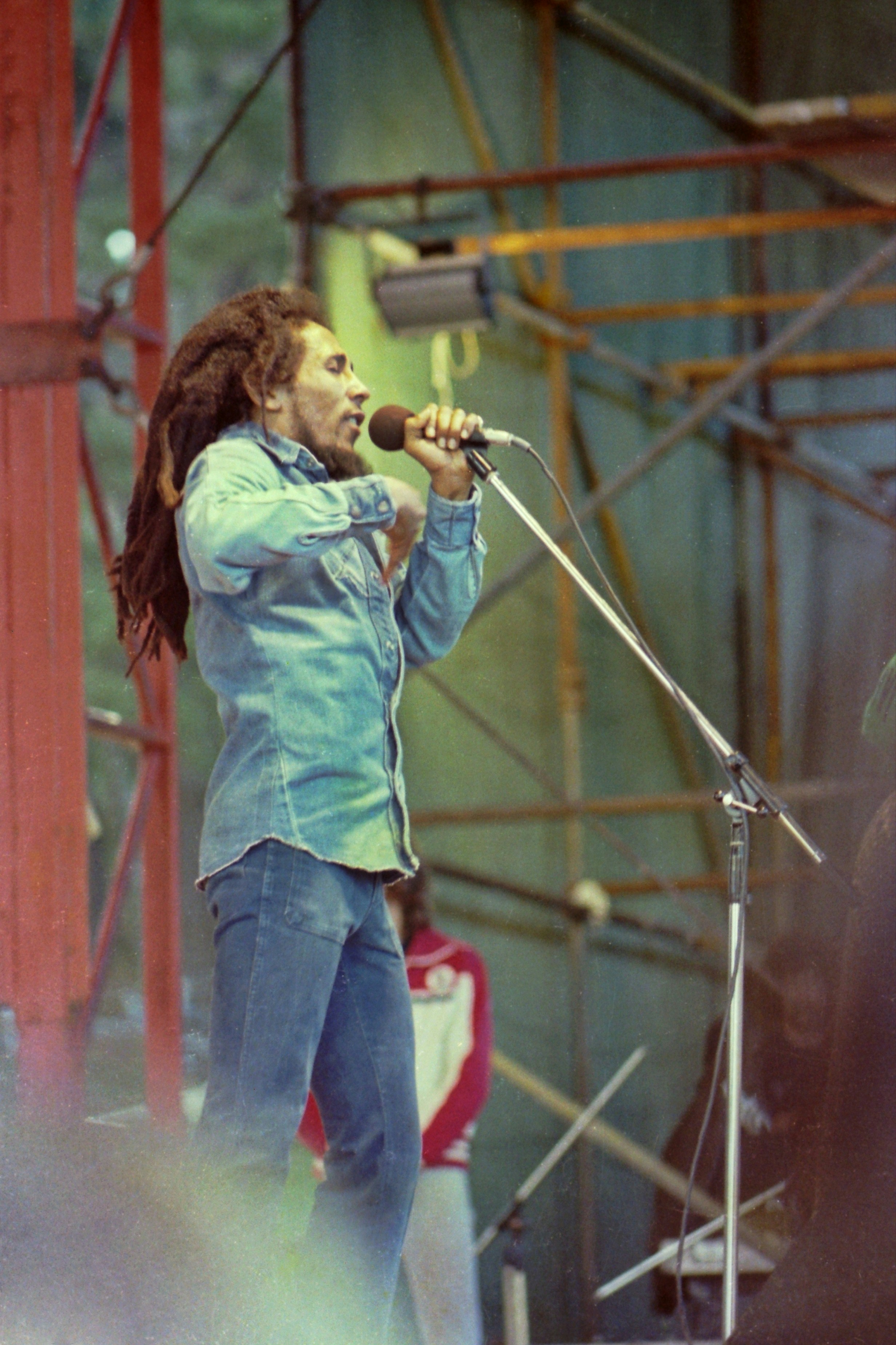 Bob marley performing on stage with microphone