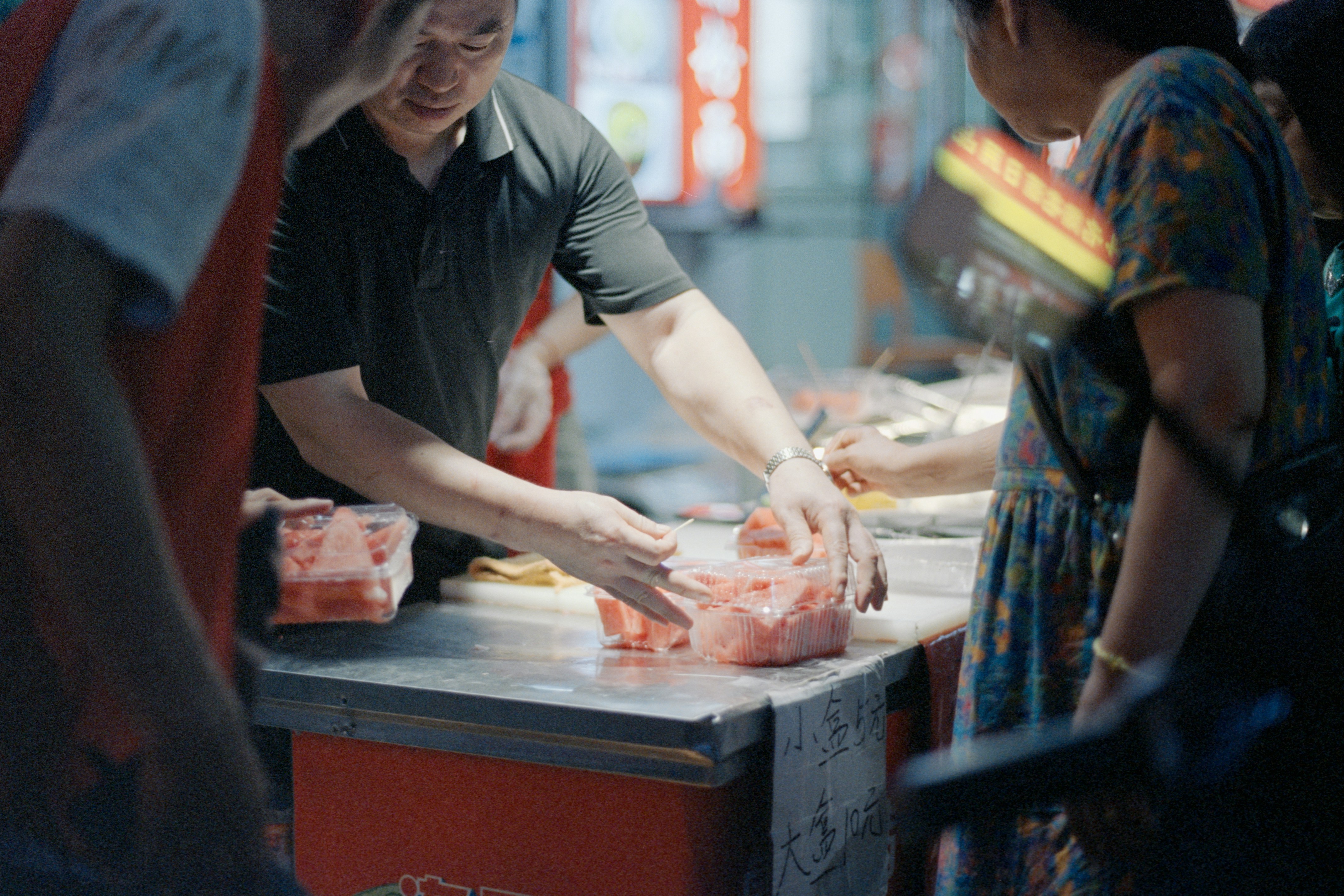 Man cutting meat at a market stall.