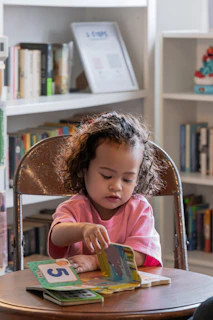 Young child focused on a book in a library.