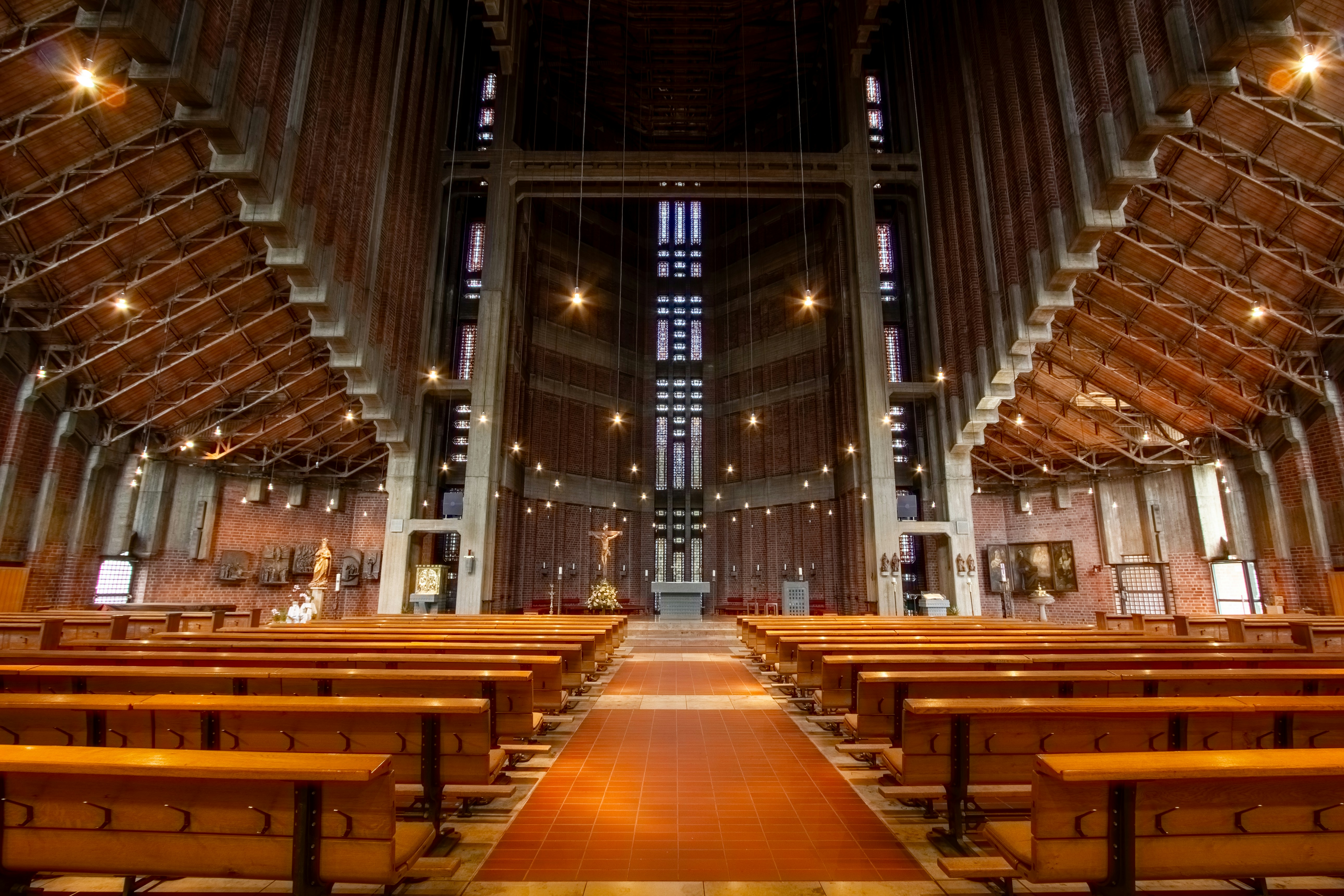 Interior of a modern church with wooden pews and high ceiling.