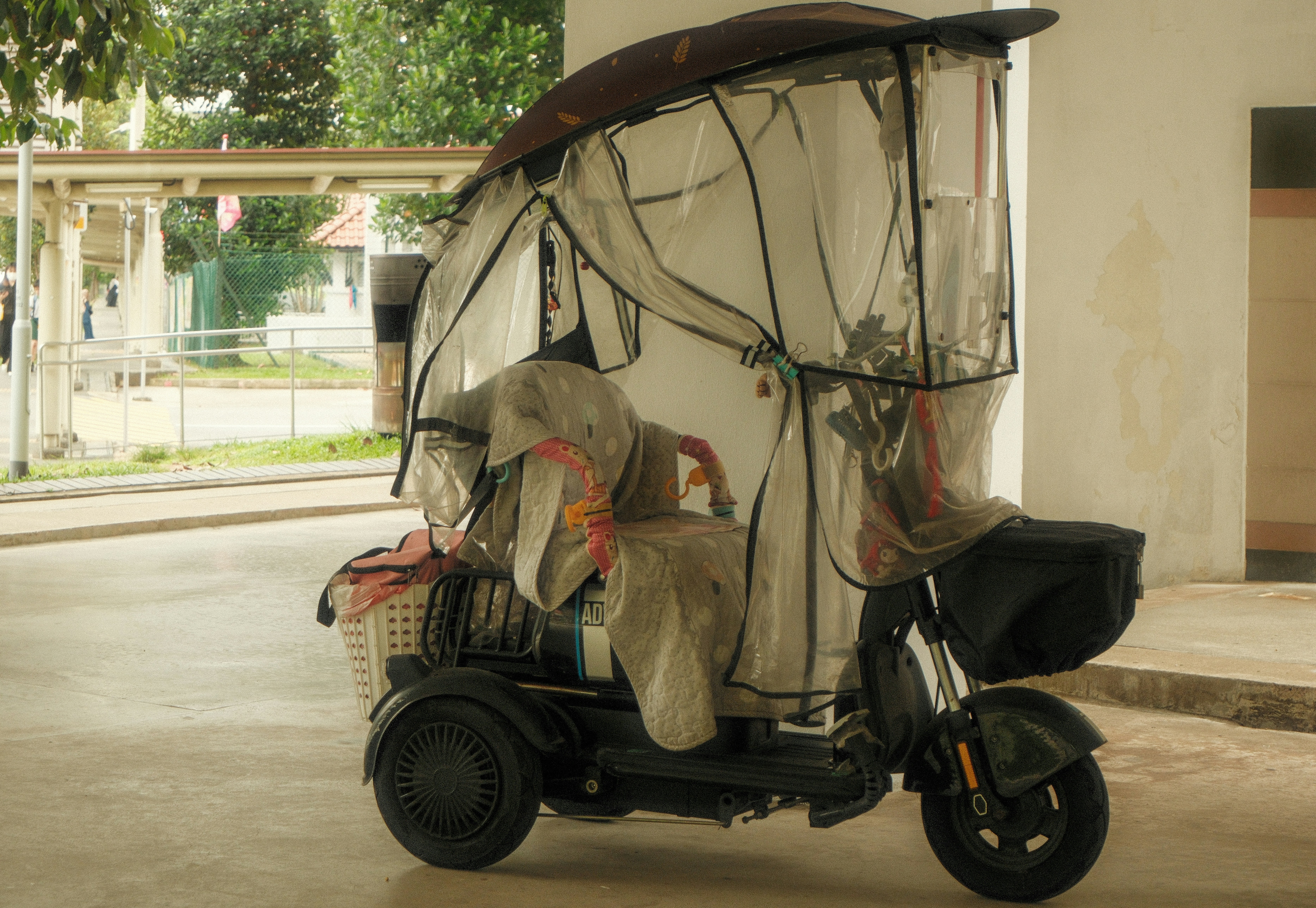 Three-wheeled scooter covered in plastic sheeting.
