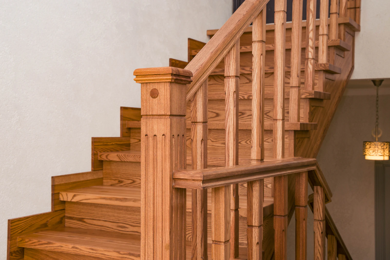 Timber staircase with turned balusters and a carved newel post