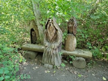 Wooden carvings of figures in a forest setting.