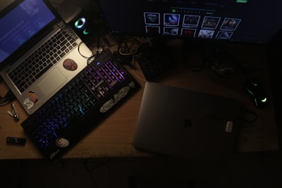 Two laptops and a keyboard on a desk.