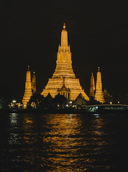 Temple of dawn illuminated at night by the river
