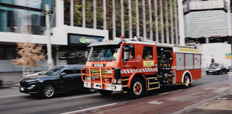 Red fire truck driving on a city street.