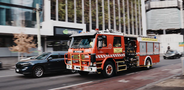 Red fire truck driving on a city street.