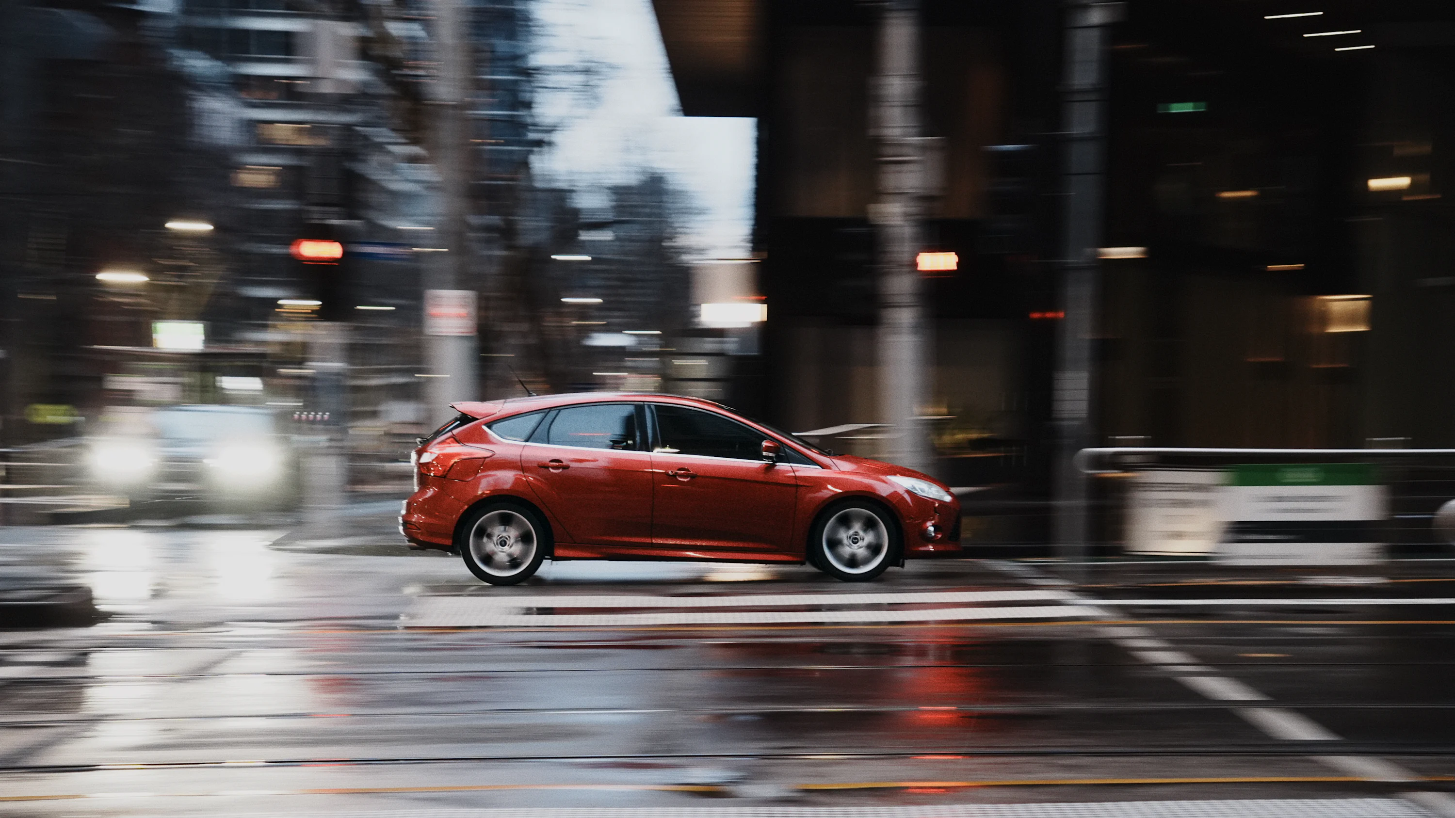 Contract de comodat auto pentru Uber si Bolt: model PDF si cerinte ARR Red car driving on wet city street at night