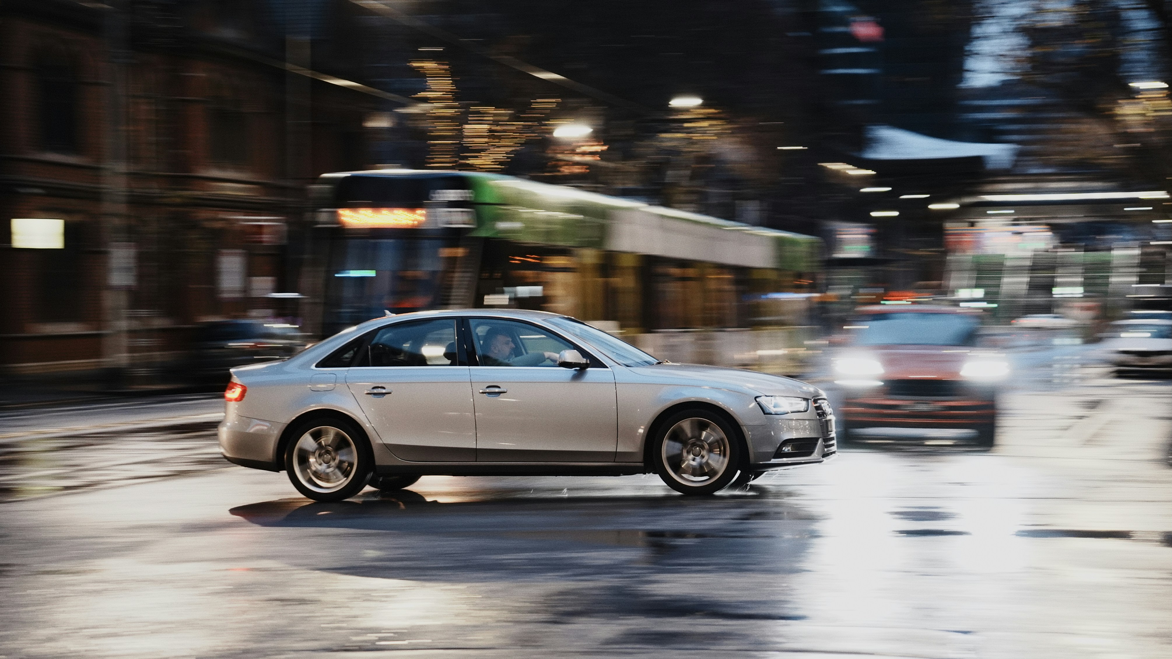 Autos, die nachts auf einer nassen Straße in der Stadt fahren.