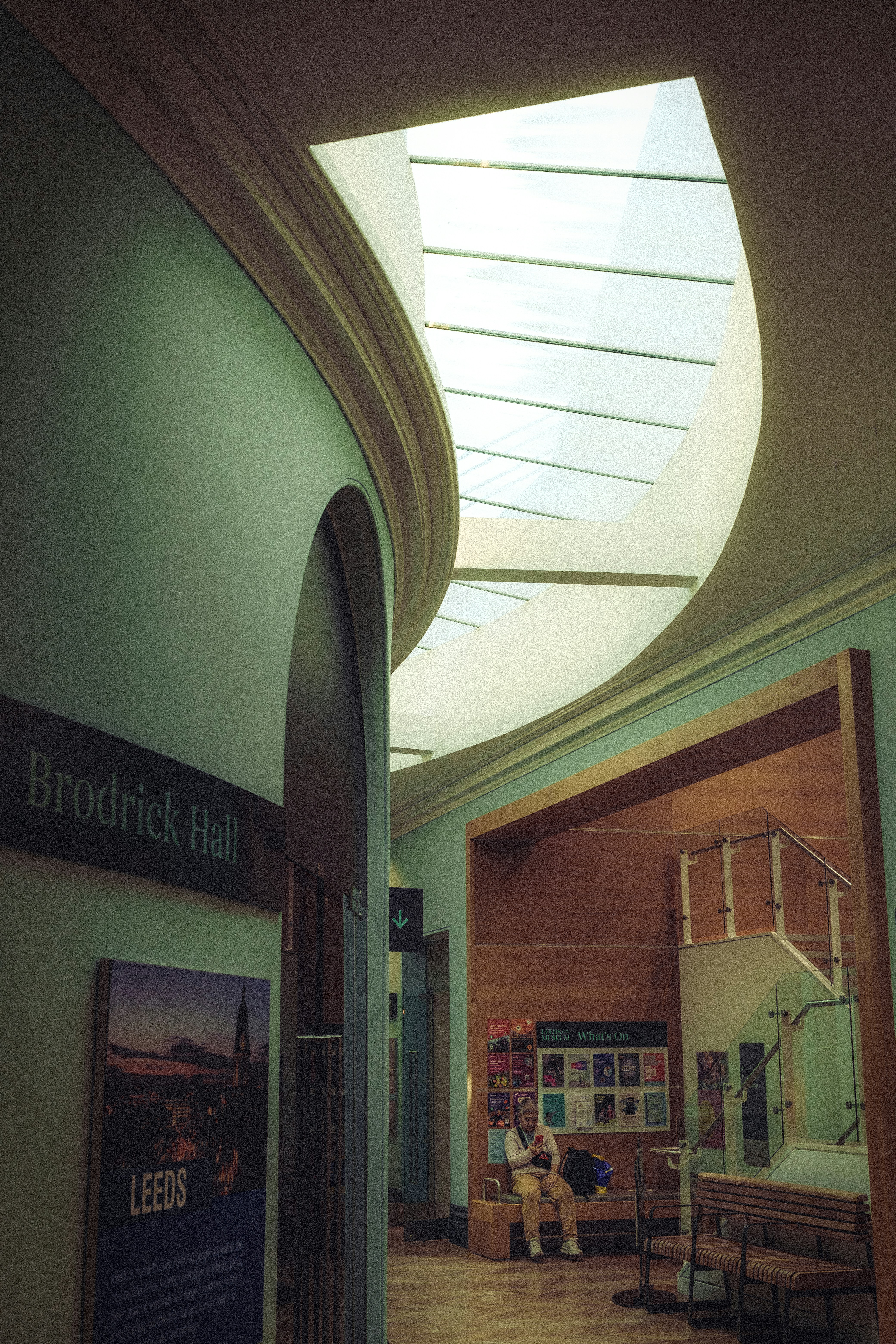 Innenflur mit einem Oberlicht und einer sitzenden Person.