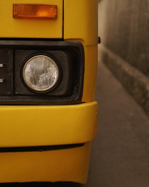 Close-up of a bright yellow bus headlight
