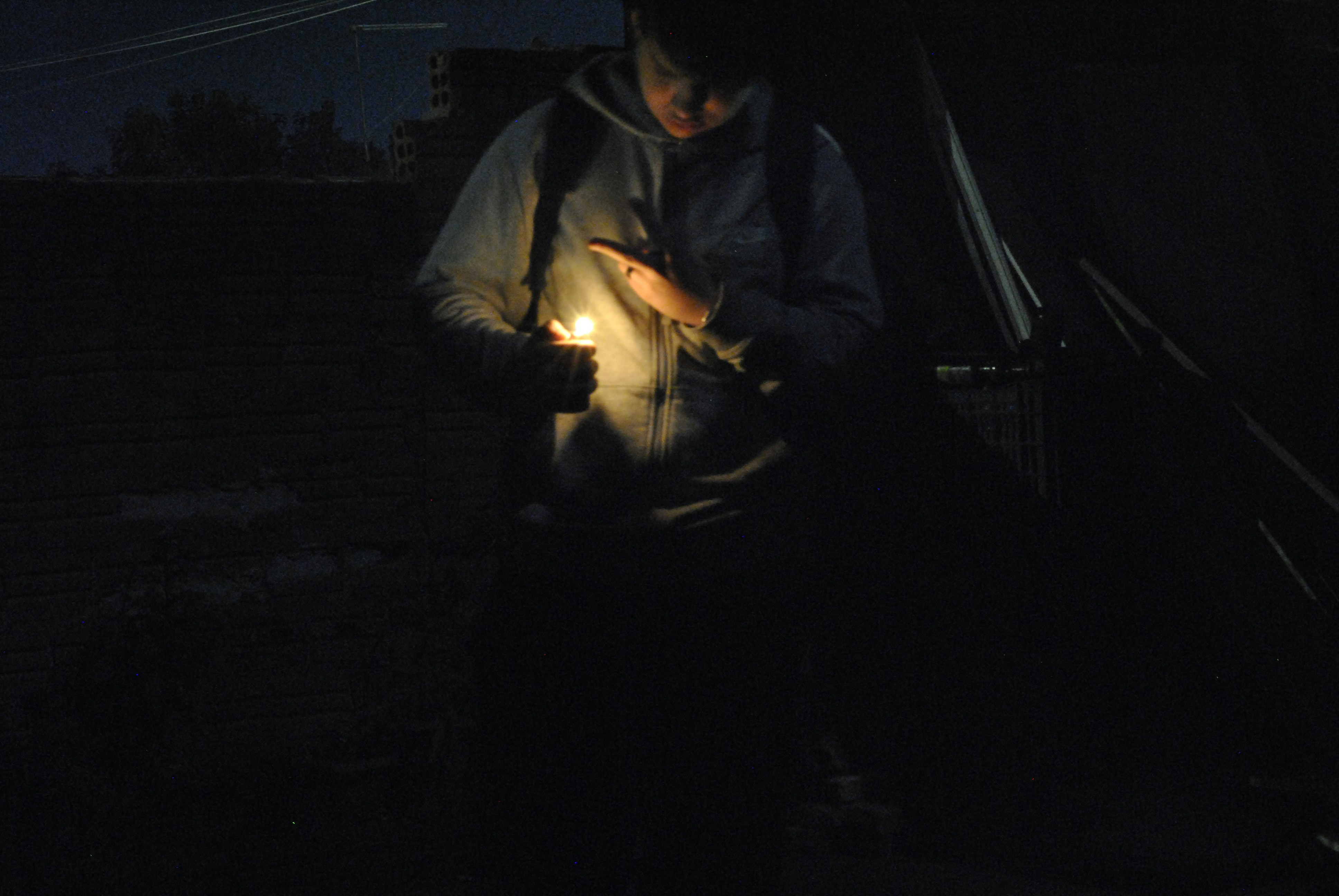 Person holding a lit lighter in the dark