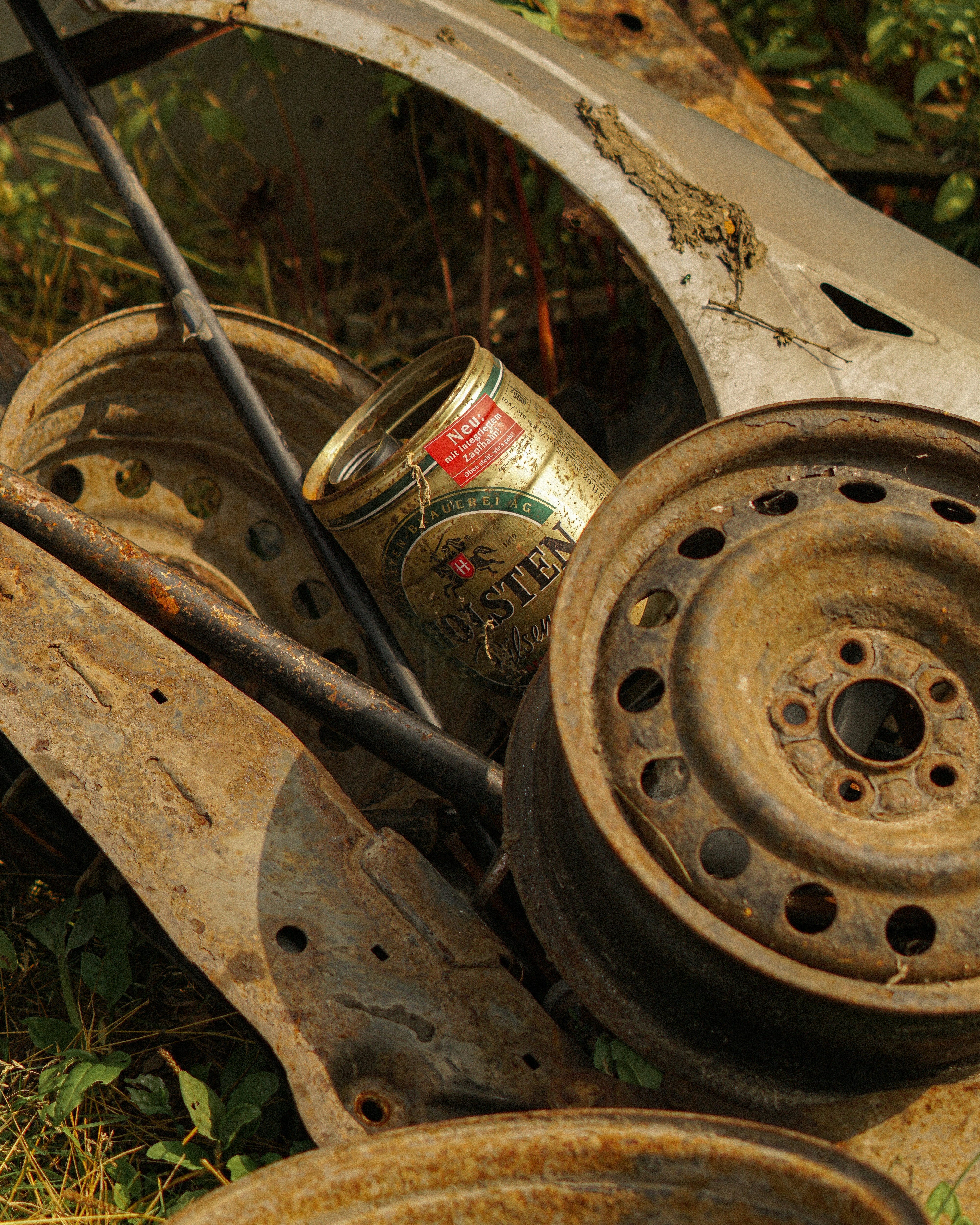Pile of rusty car parts and a beer can.