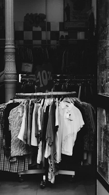 Clothing rack with various shirts and dresses on display.