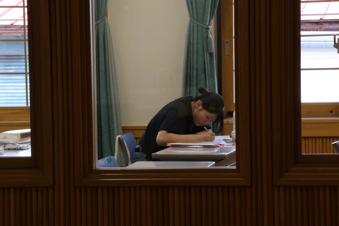 A person studying at a desk surrounded by books and notes