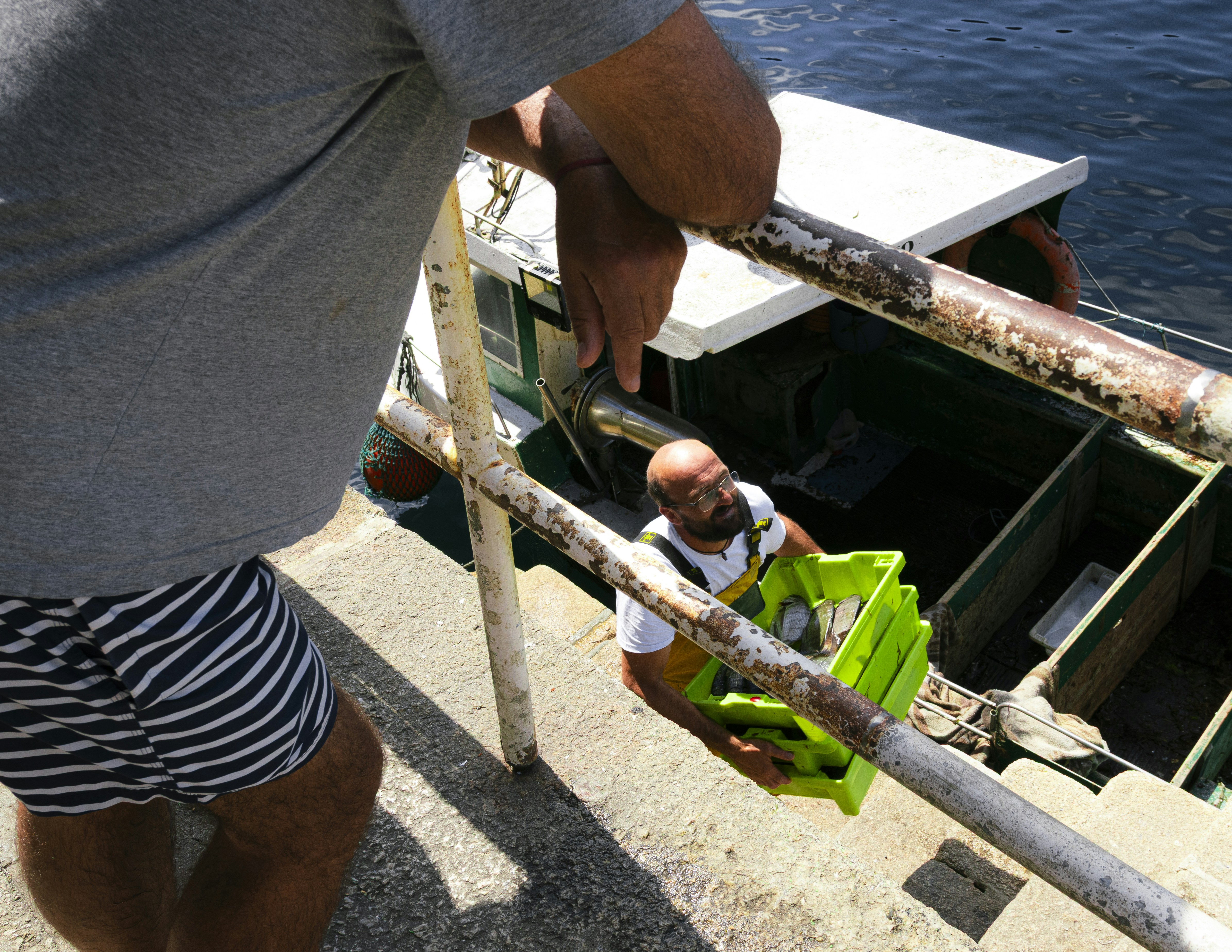 Pescadores cargando cajas en un barco