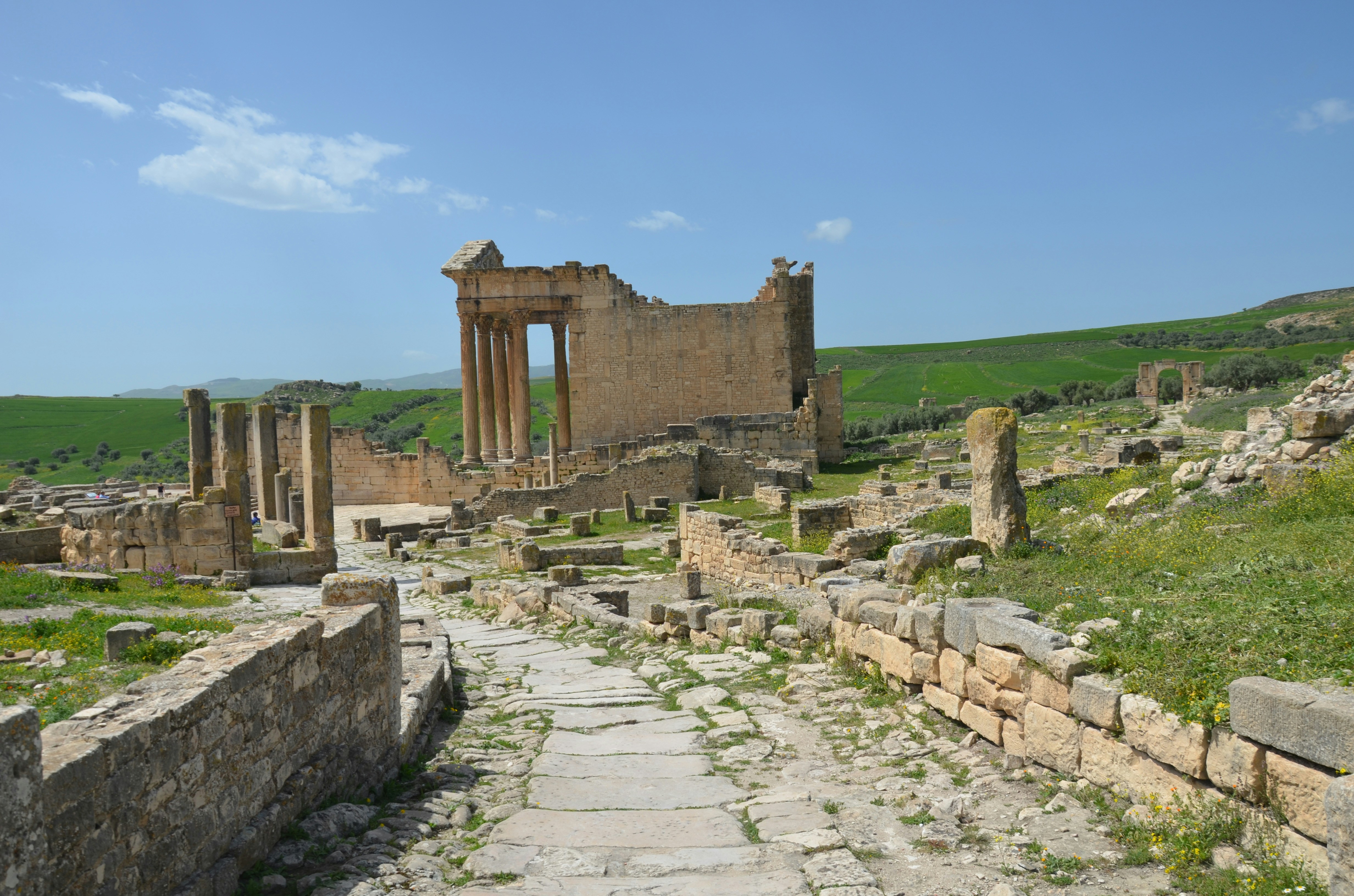 Ancient ruins with stone pathway under blue sky