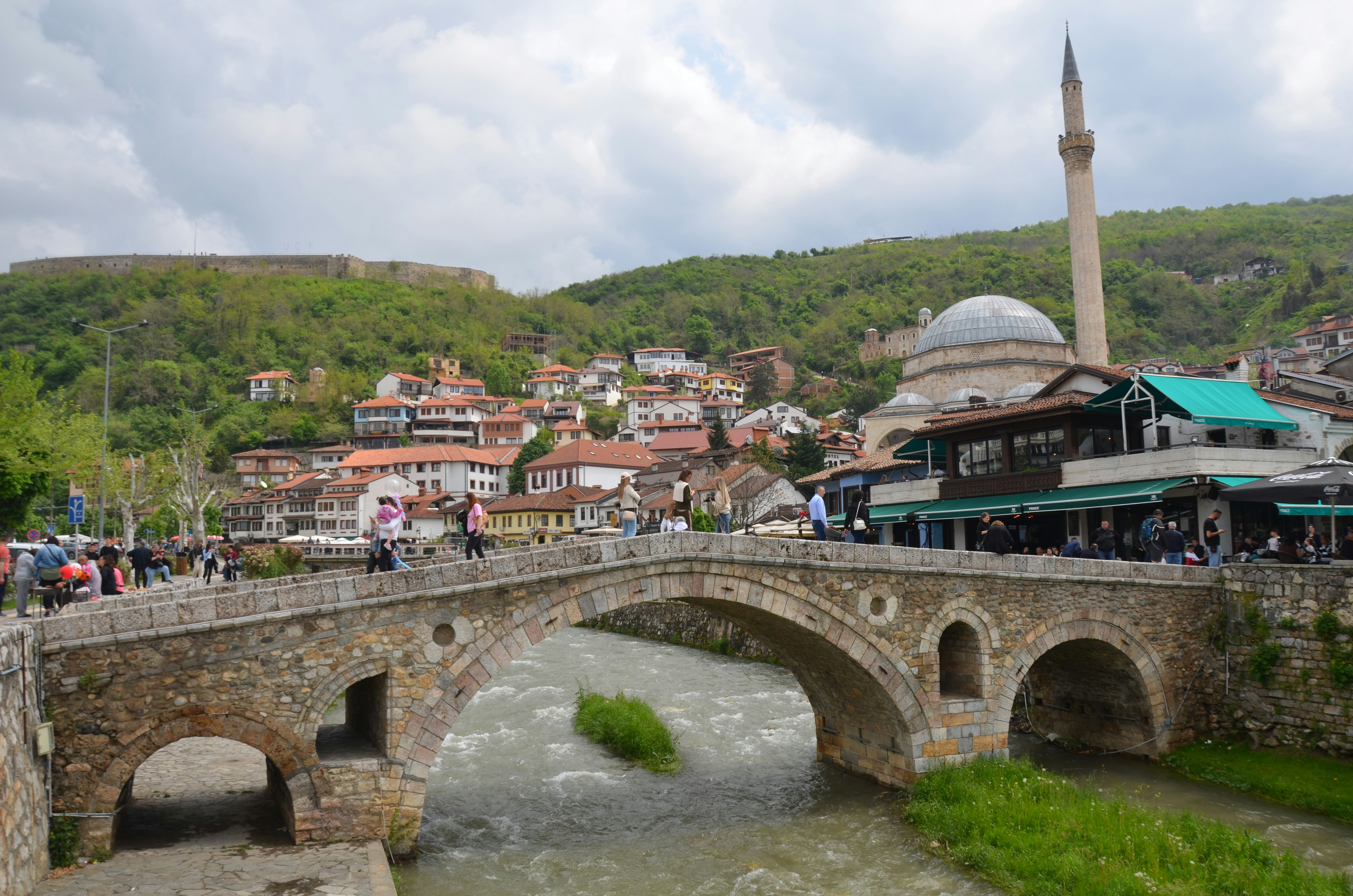 Stone bridge over river with mosque and castle
