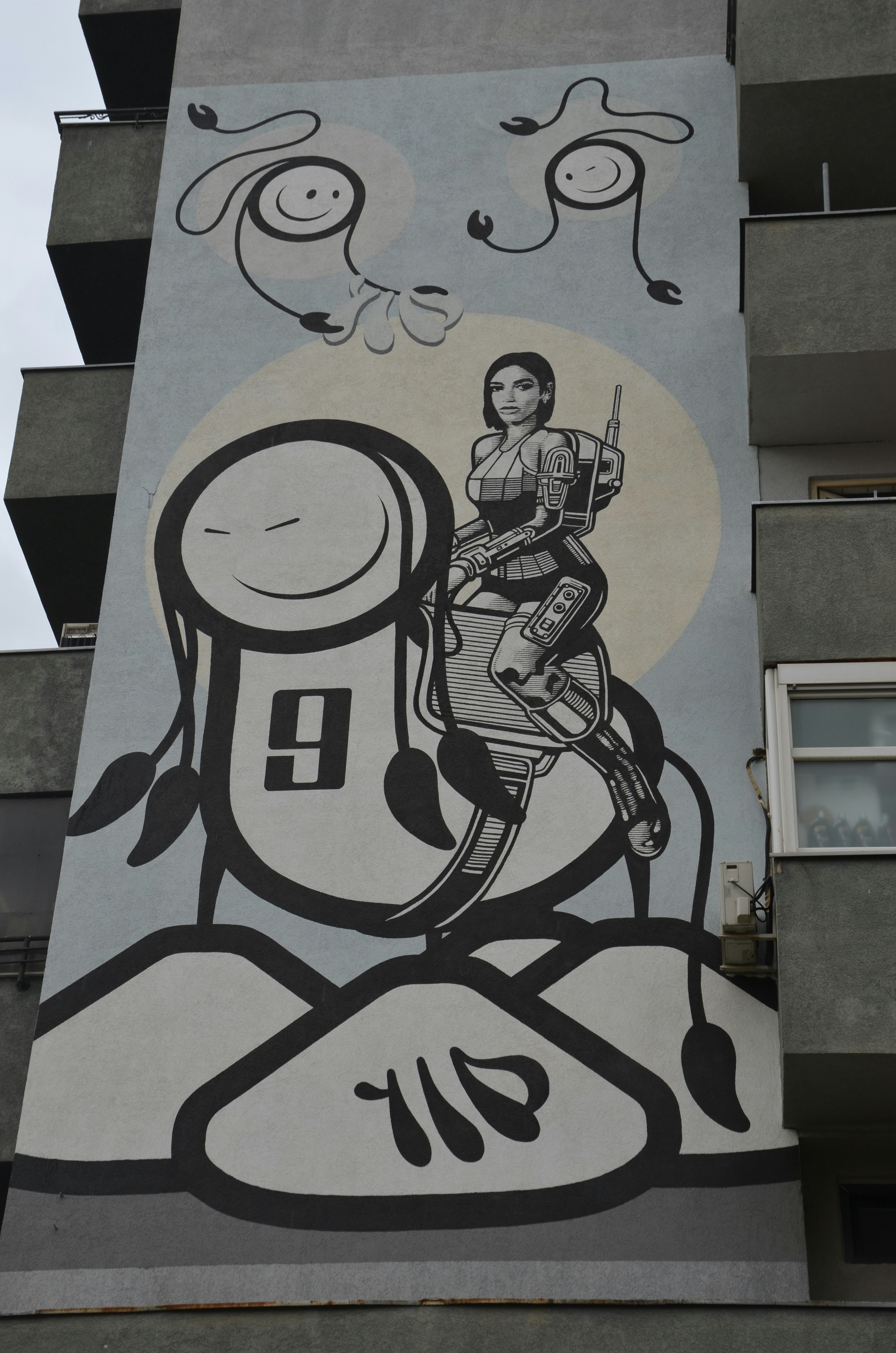 Mural on building with futuristic woman riding robot.
