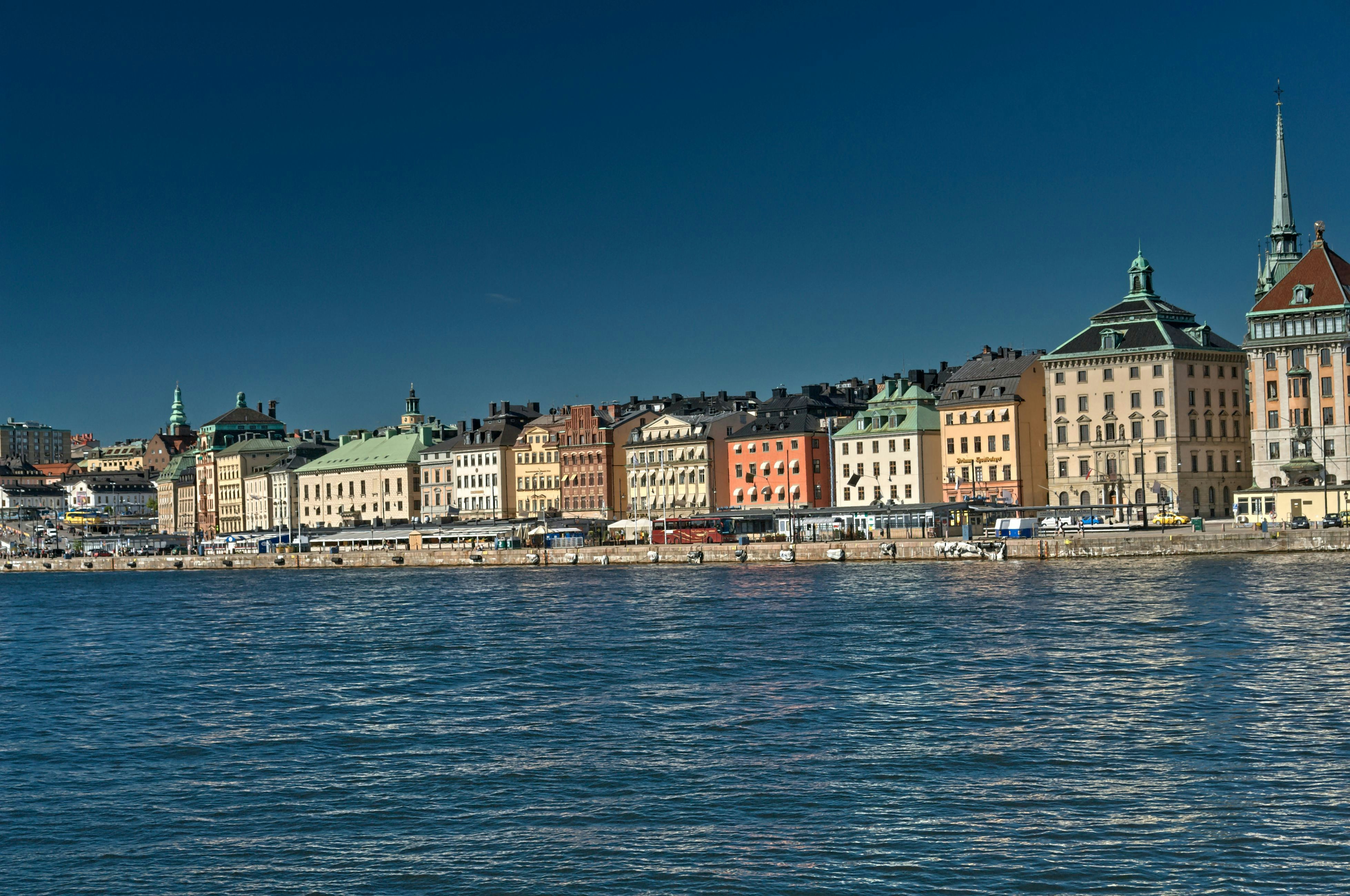 Colorful buildings line a waterfront under a clear blue sky.