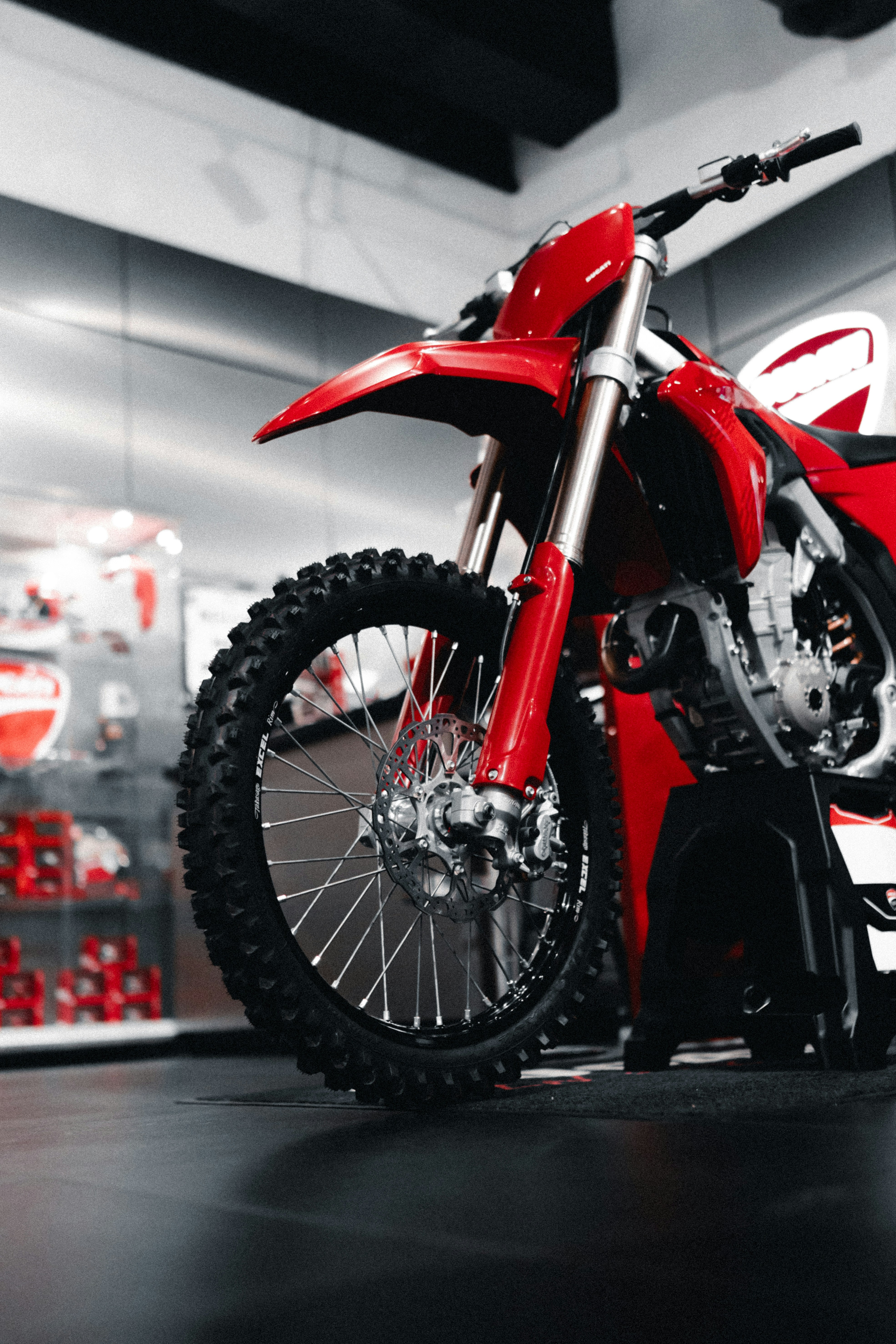 Red dirt bike parked in a showroom.