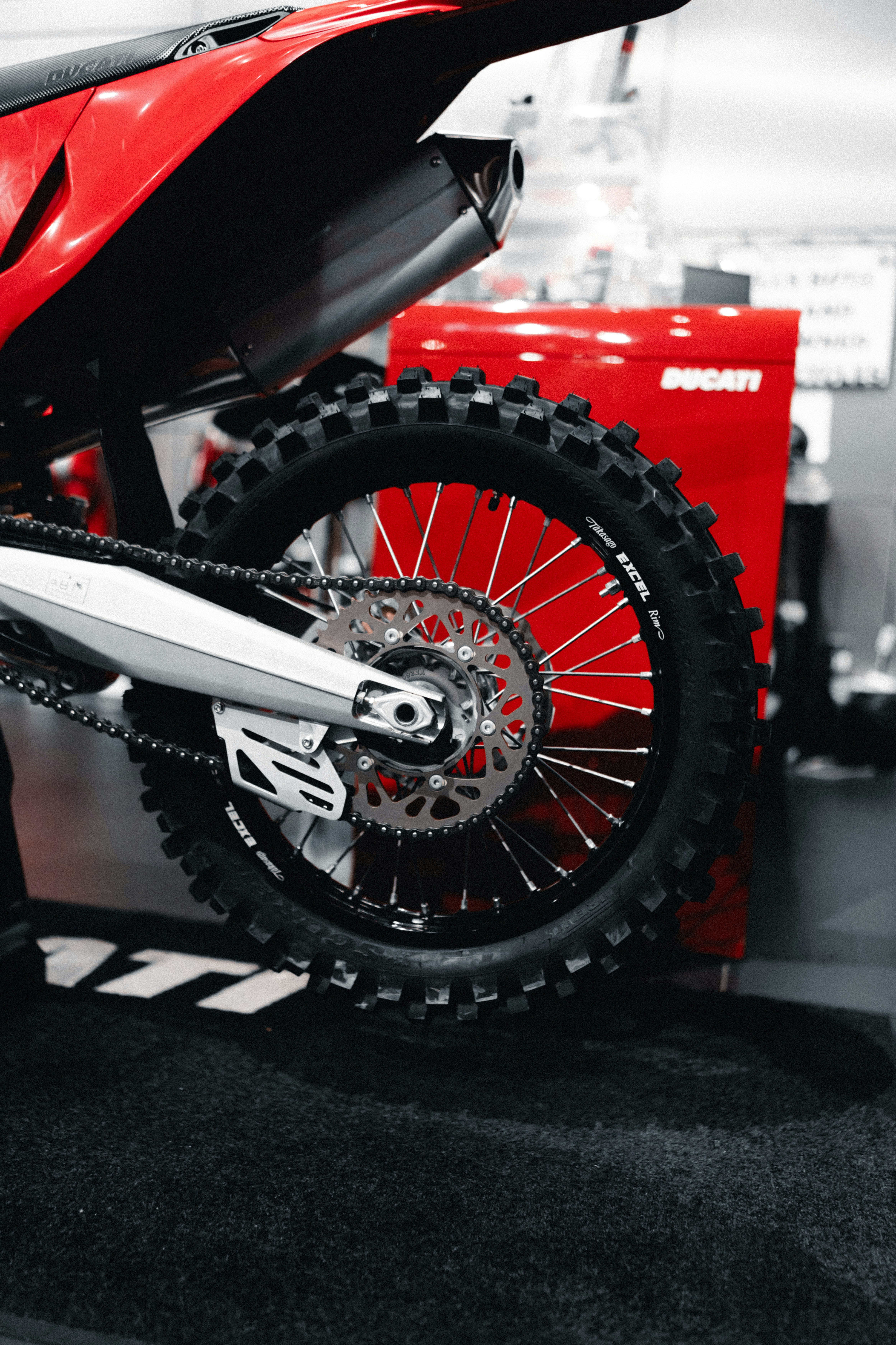 赤いダートバイクの後輪とサスペンションの詳細