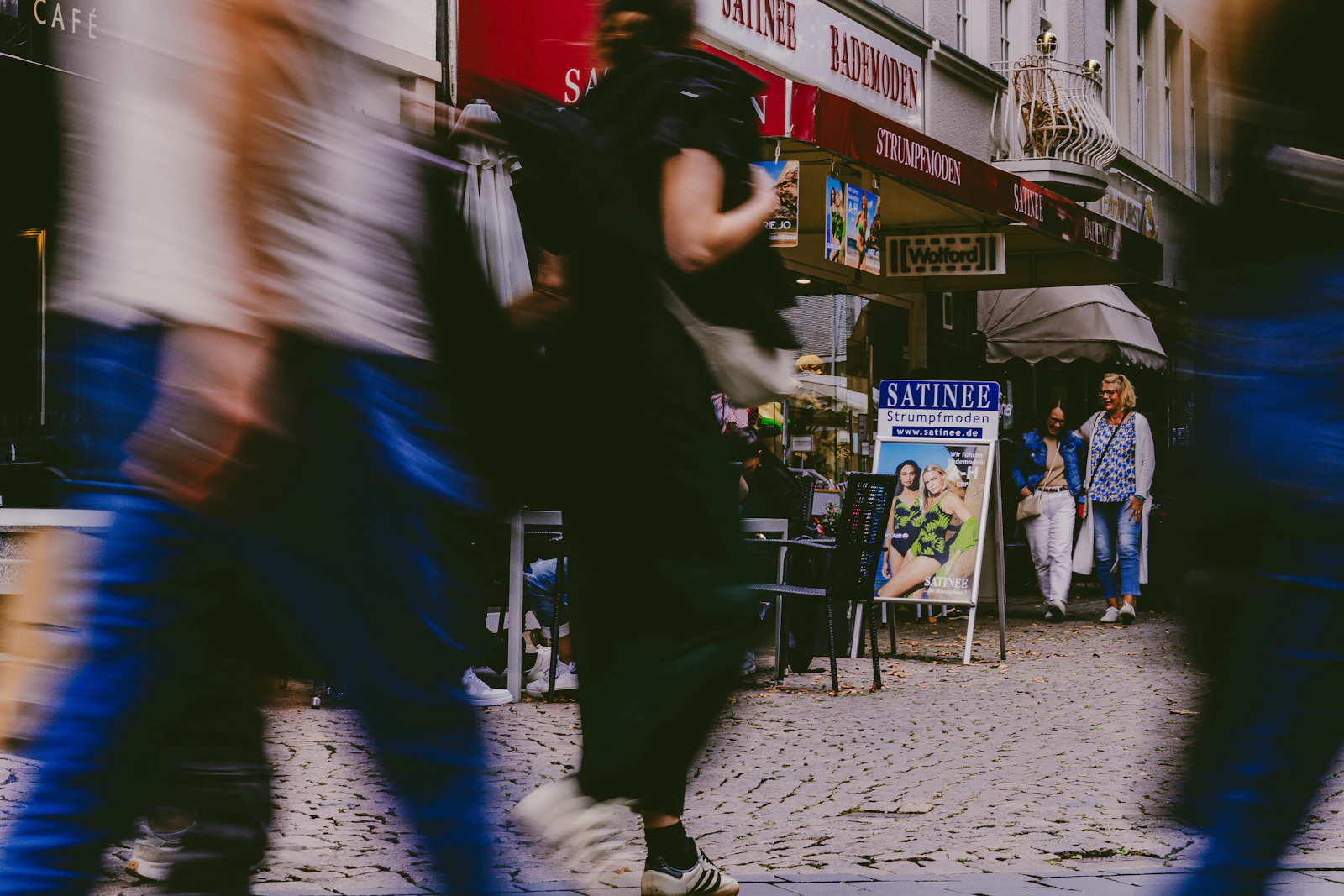 People walking along a busy city street, captured with motion blur