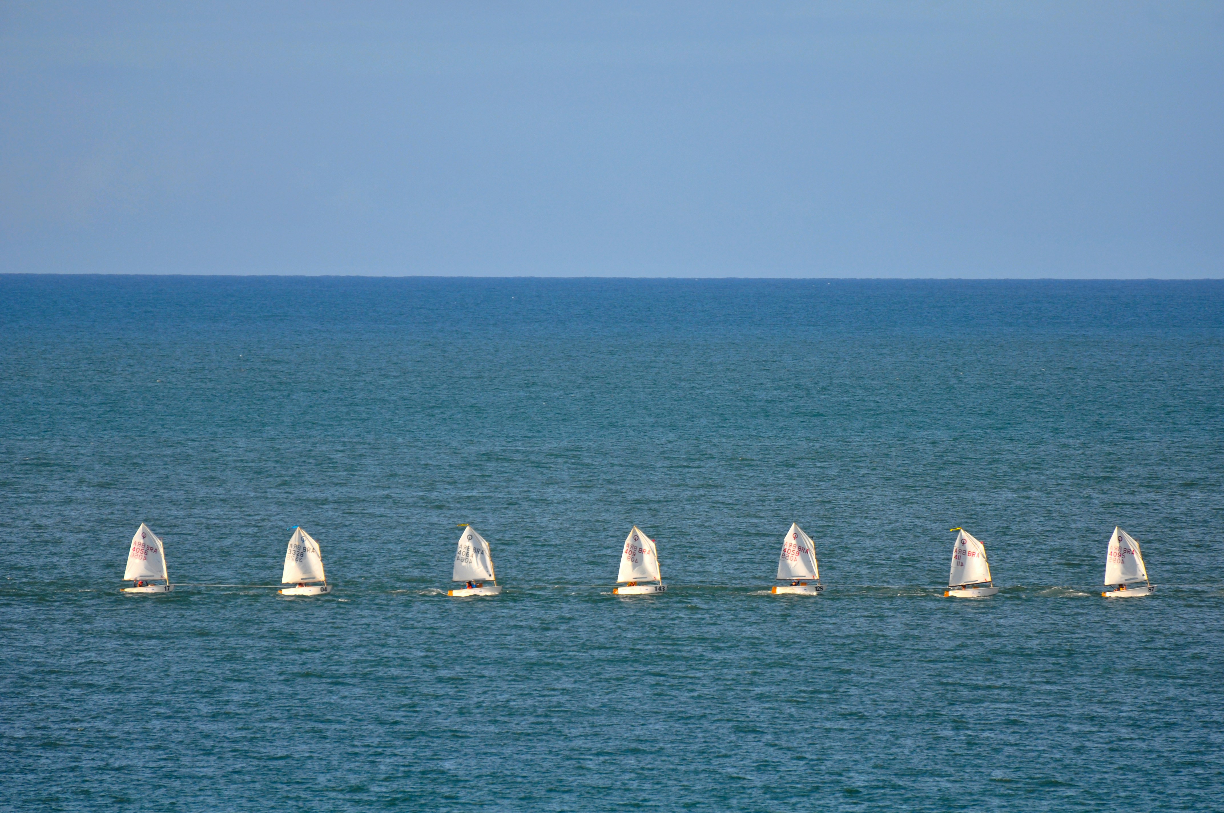 Eight sailboats racing on the sea