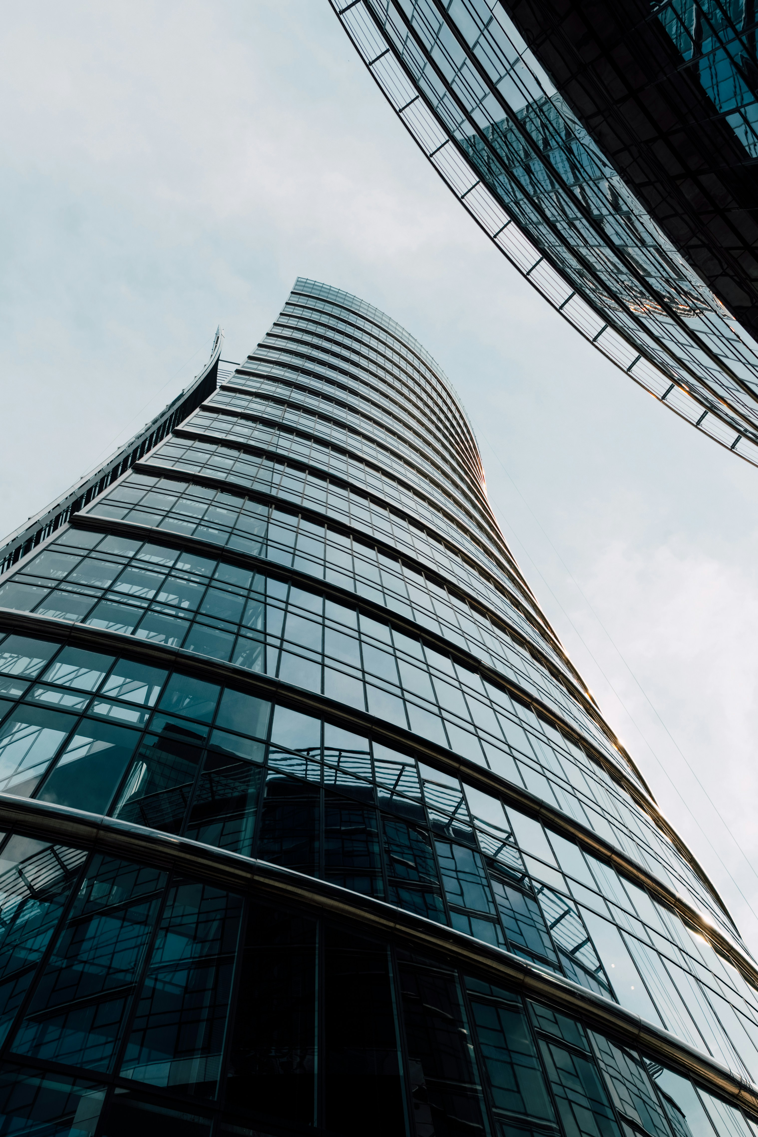 Modern glass skyscrapers against a cloudy sky.