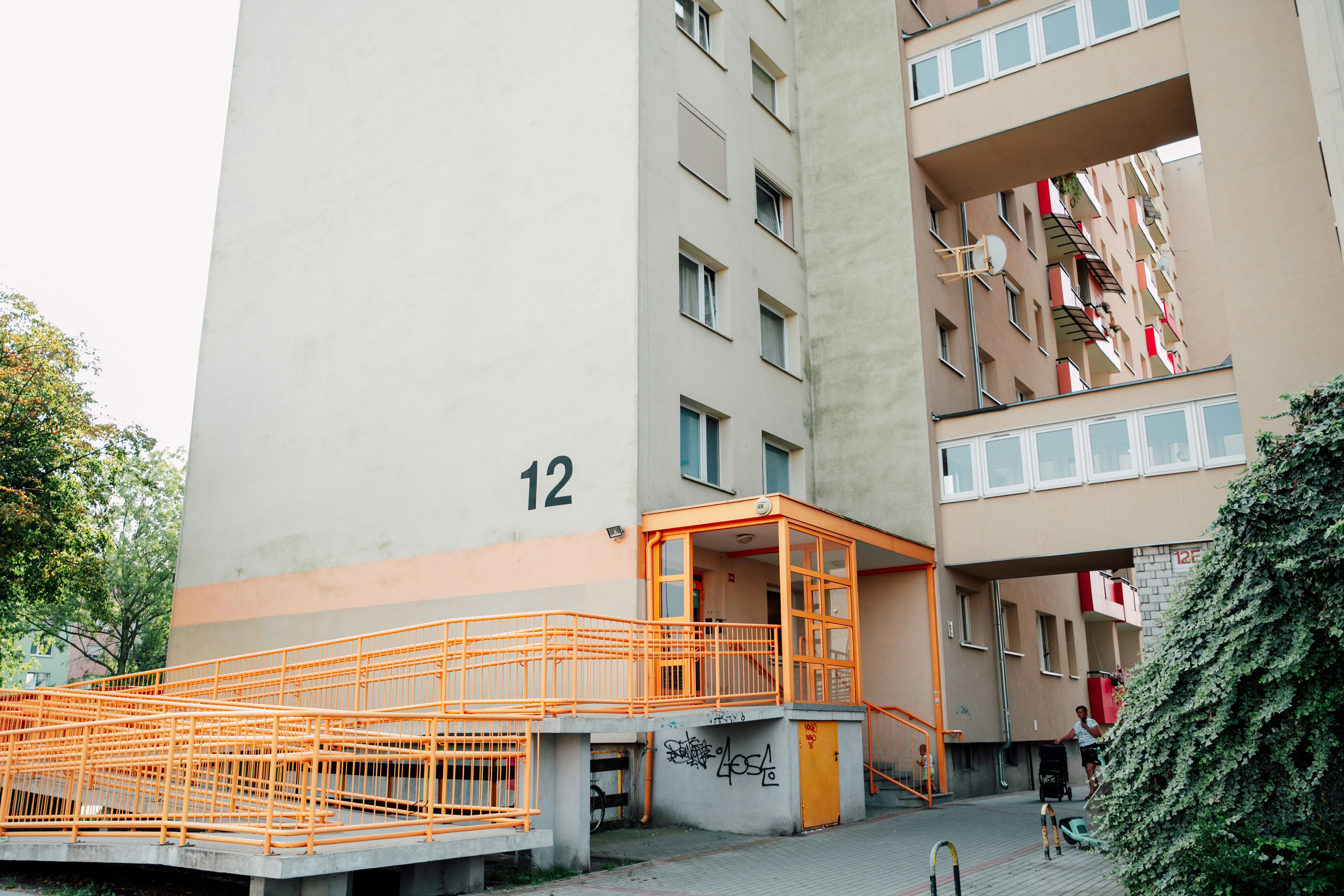 Modern apartment building with orange ramp and walkway