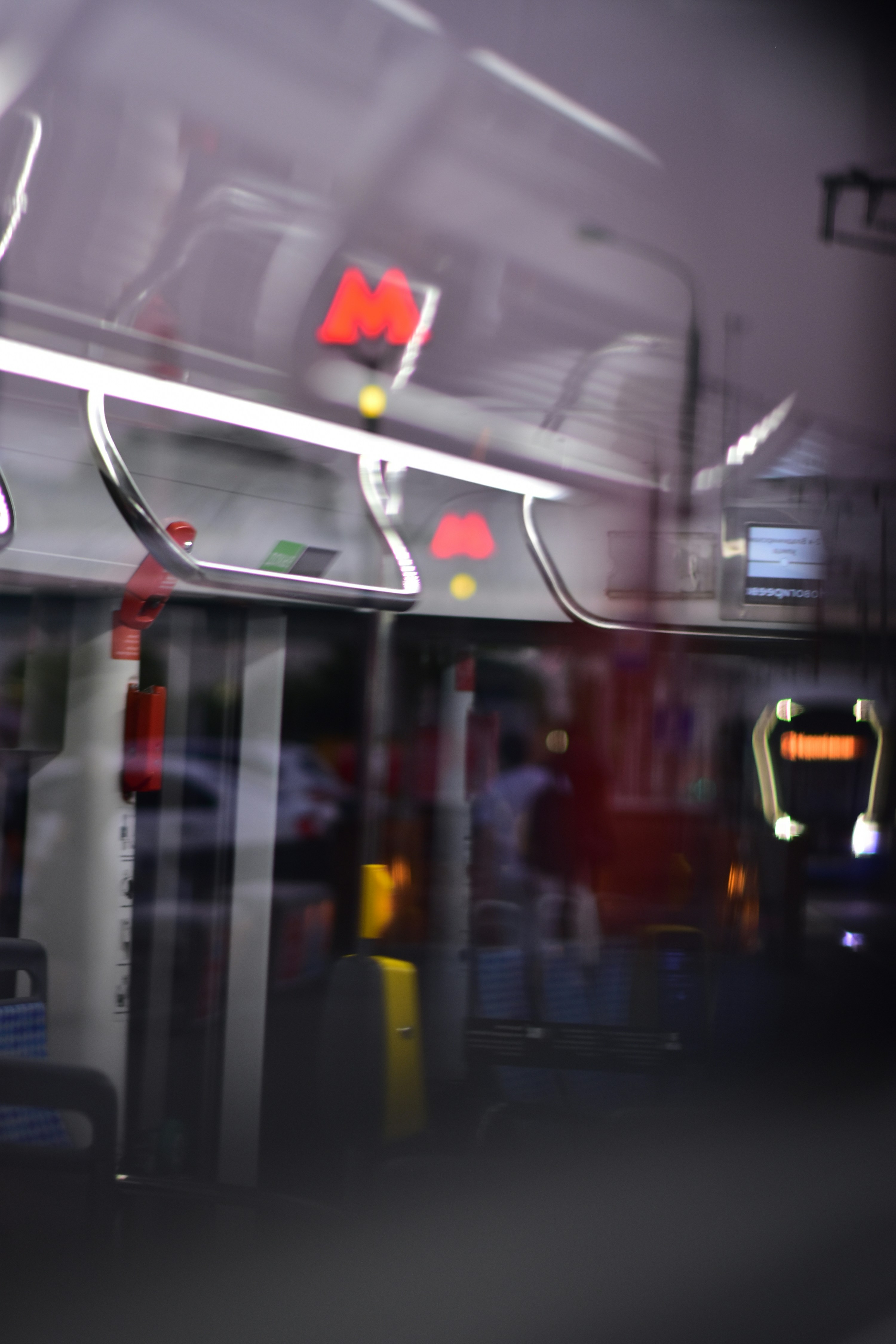 Blurred interior of a moving bus at night.