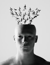 Abstract human head with flock of birds emerging