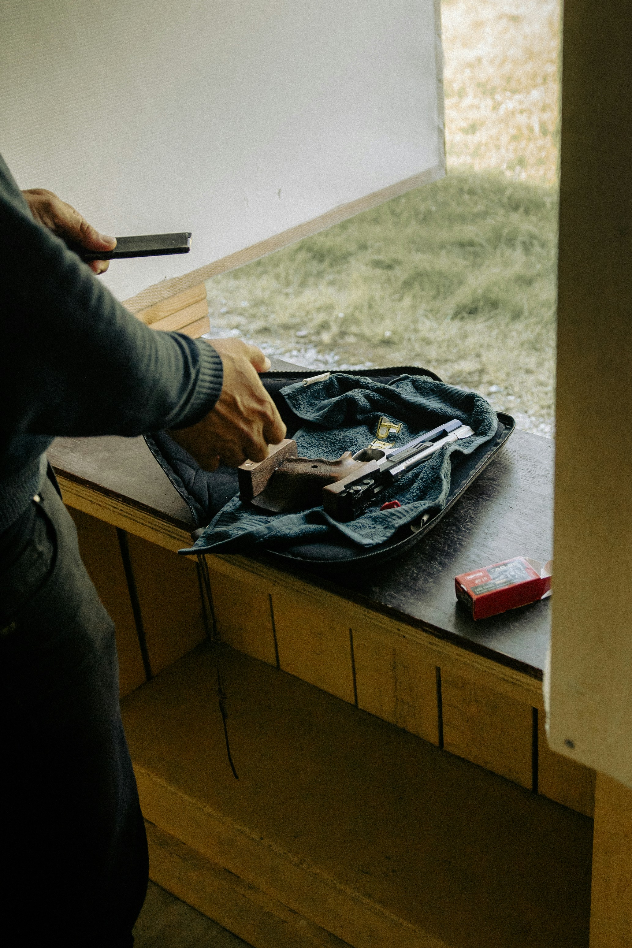 Person loading a handgun at a shooting range.