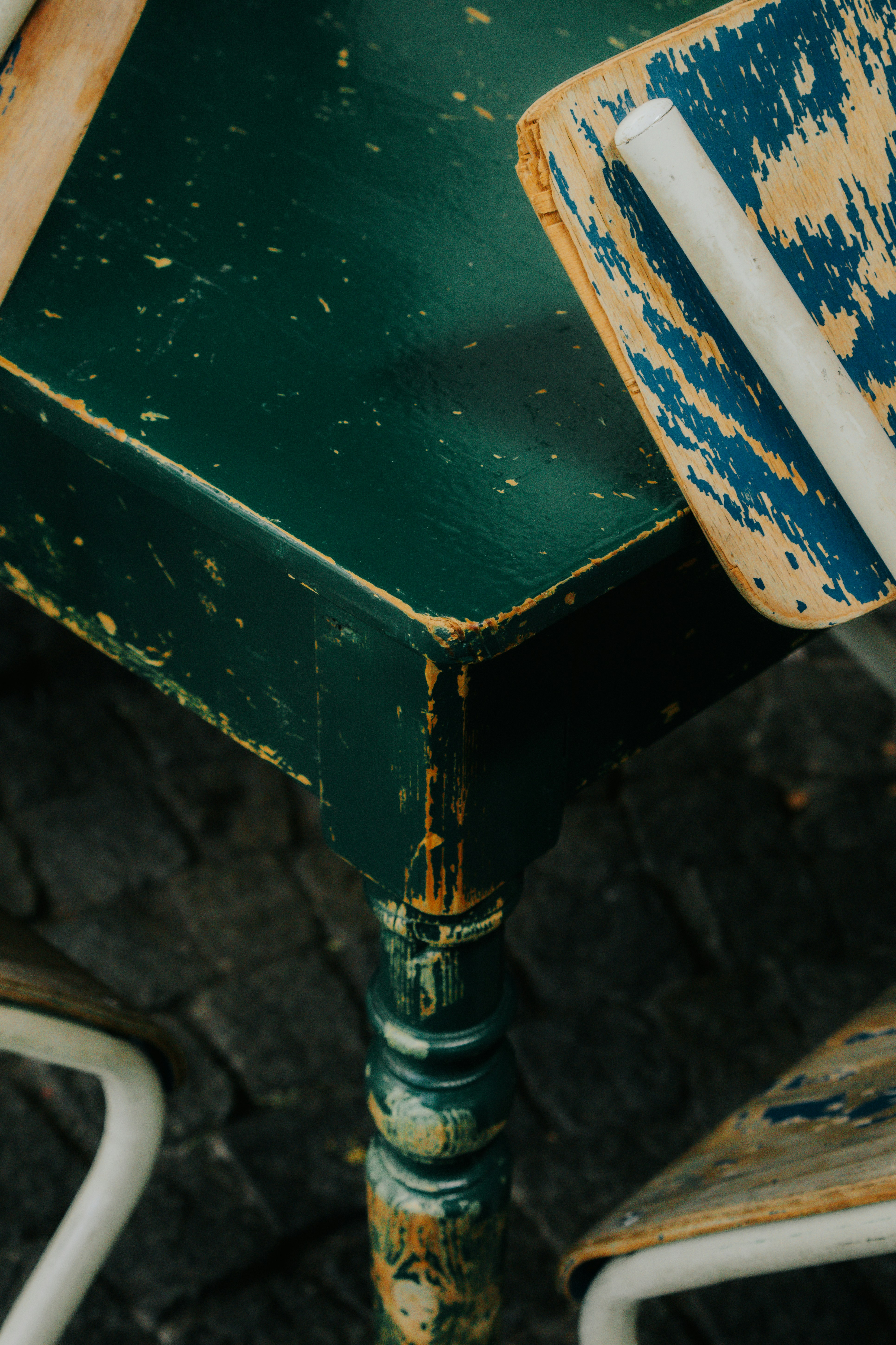 Distressed green table with chairs on rustic chairs.