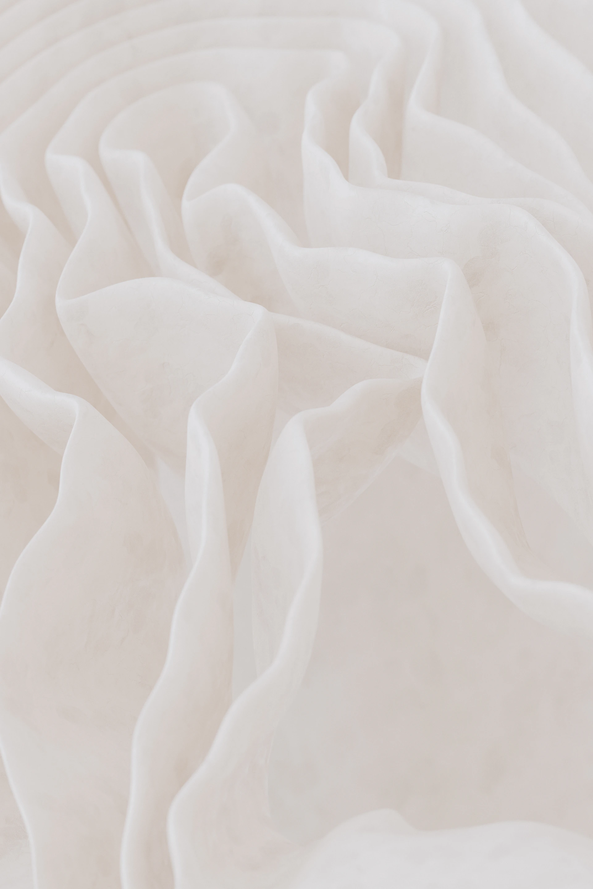 Soft white fabric folds with gentle texture.