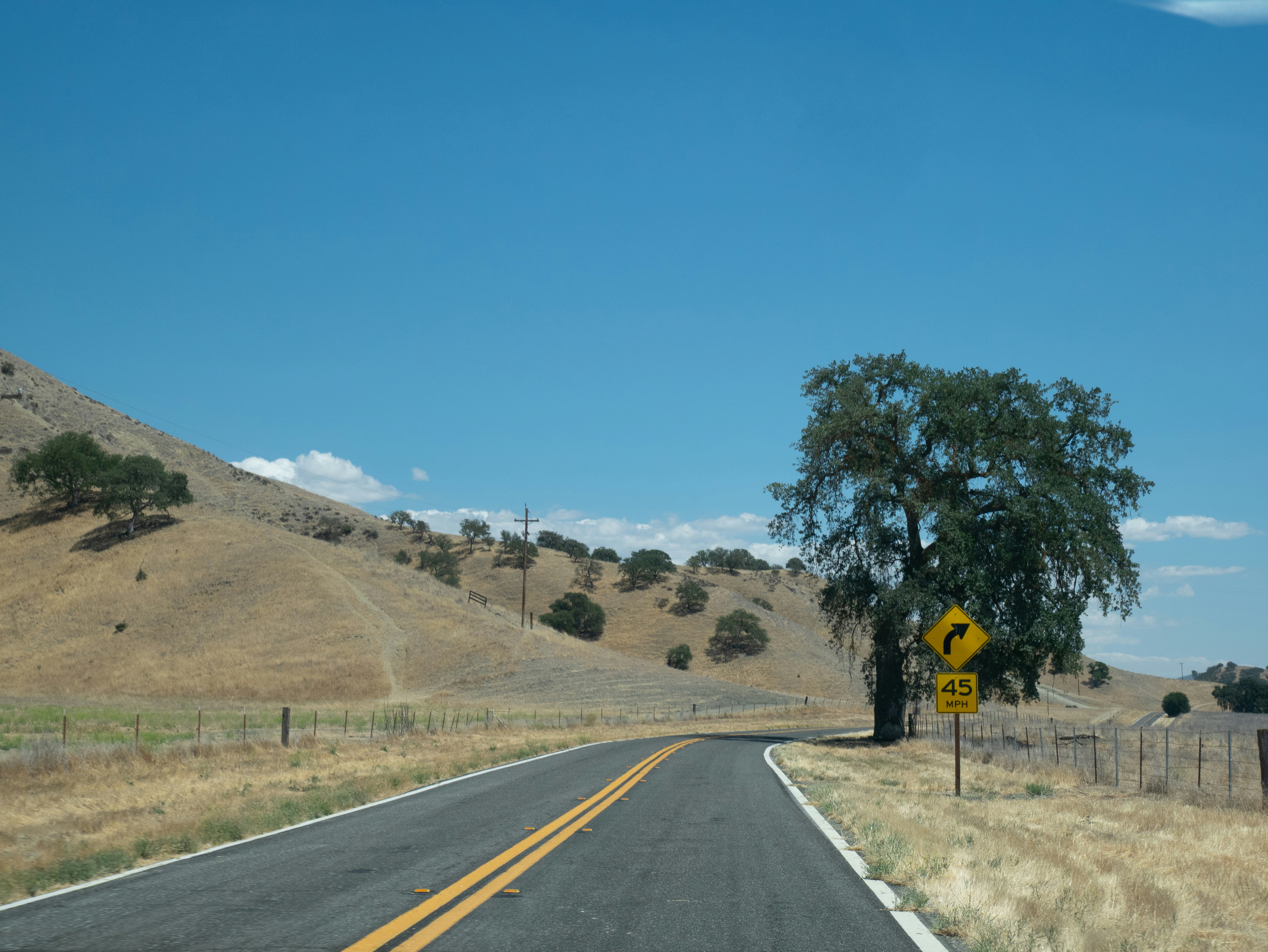 A winding road through a dry, hilly landscape.