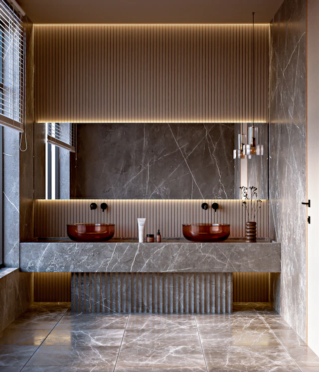 Grey marble vanity with a fluted front and two red basins