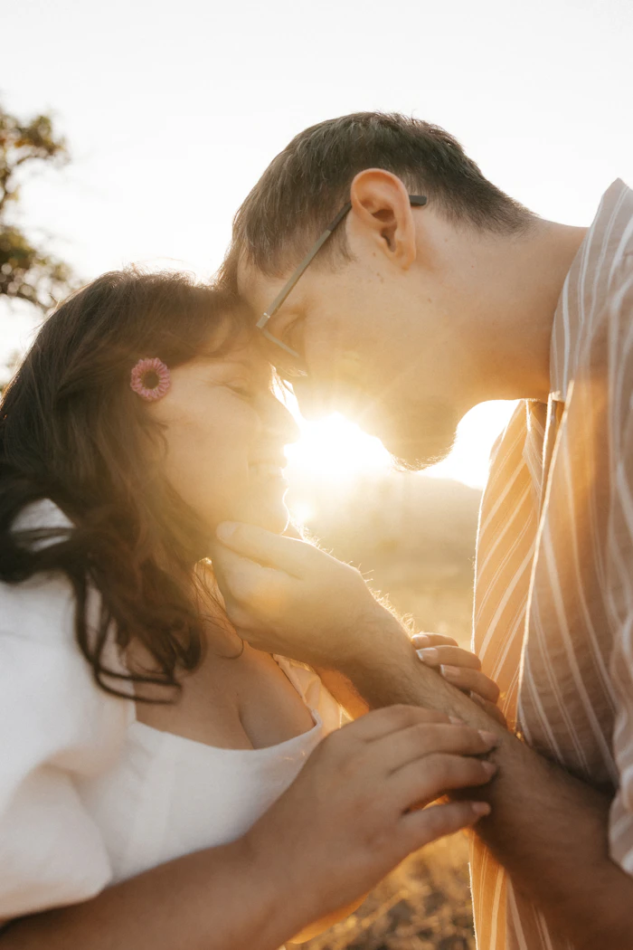A couple embracing closely outdoors during golden hour