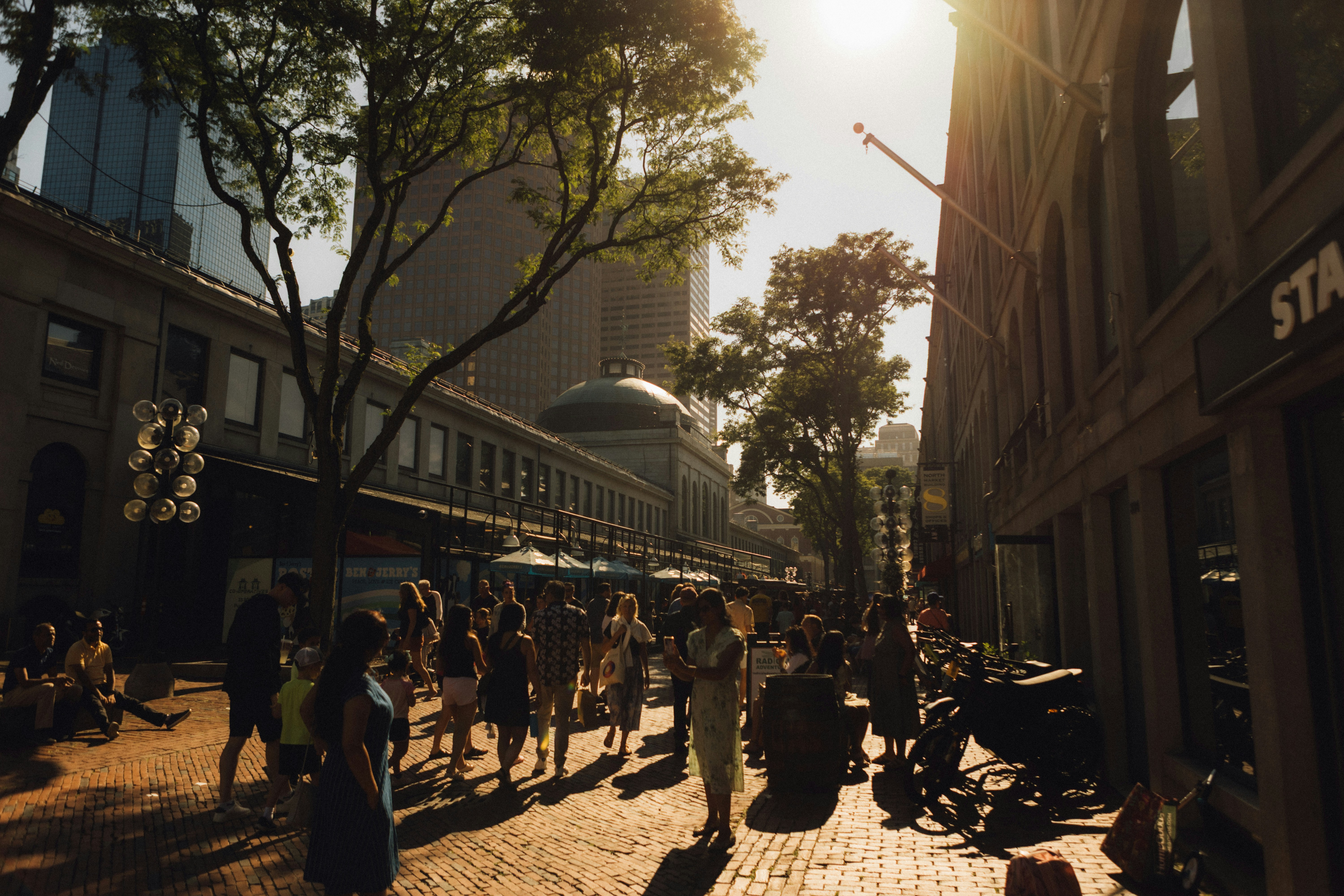 People walking down a sunny city street.