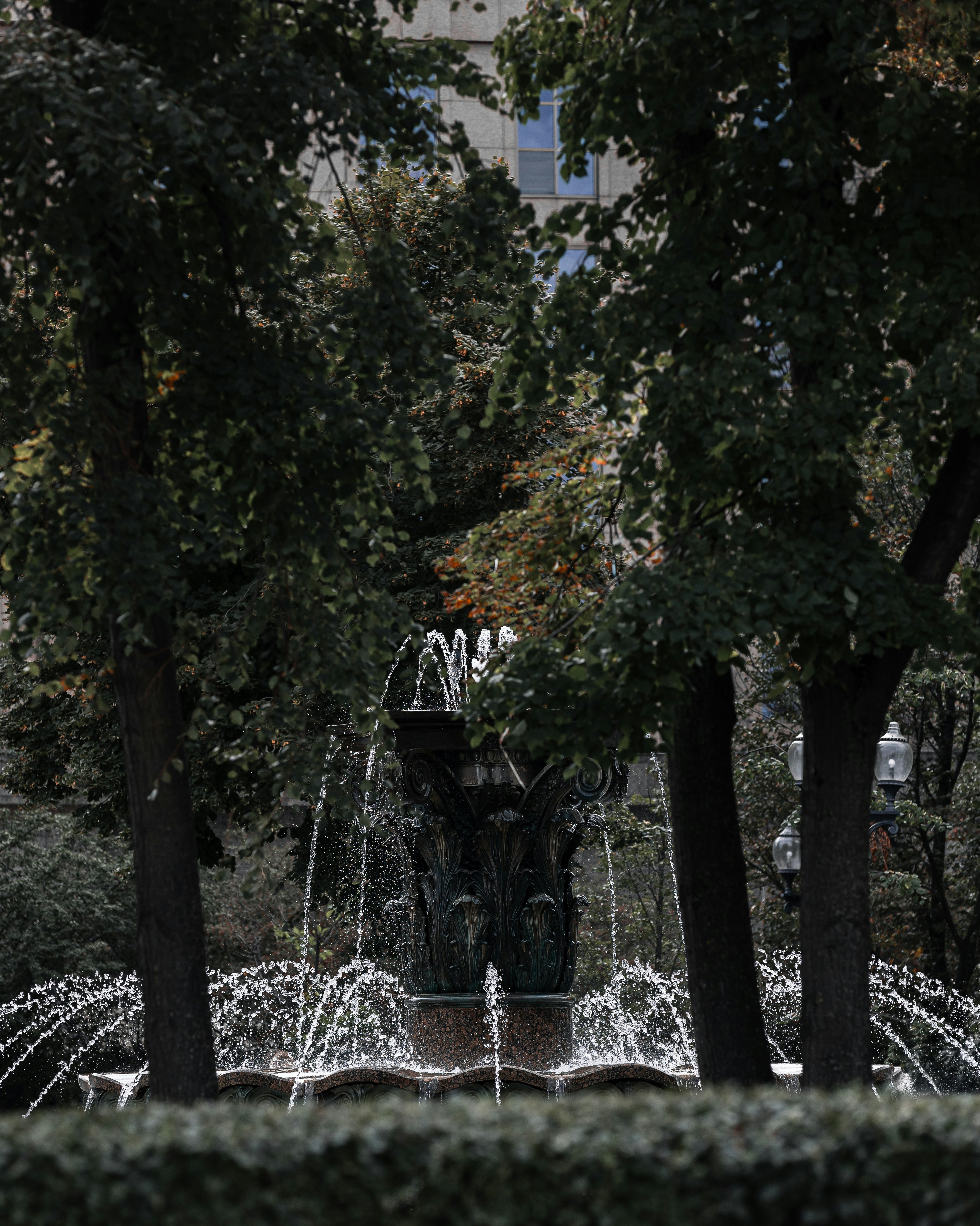 A decorative fountain sprays water in a park.