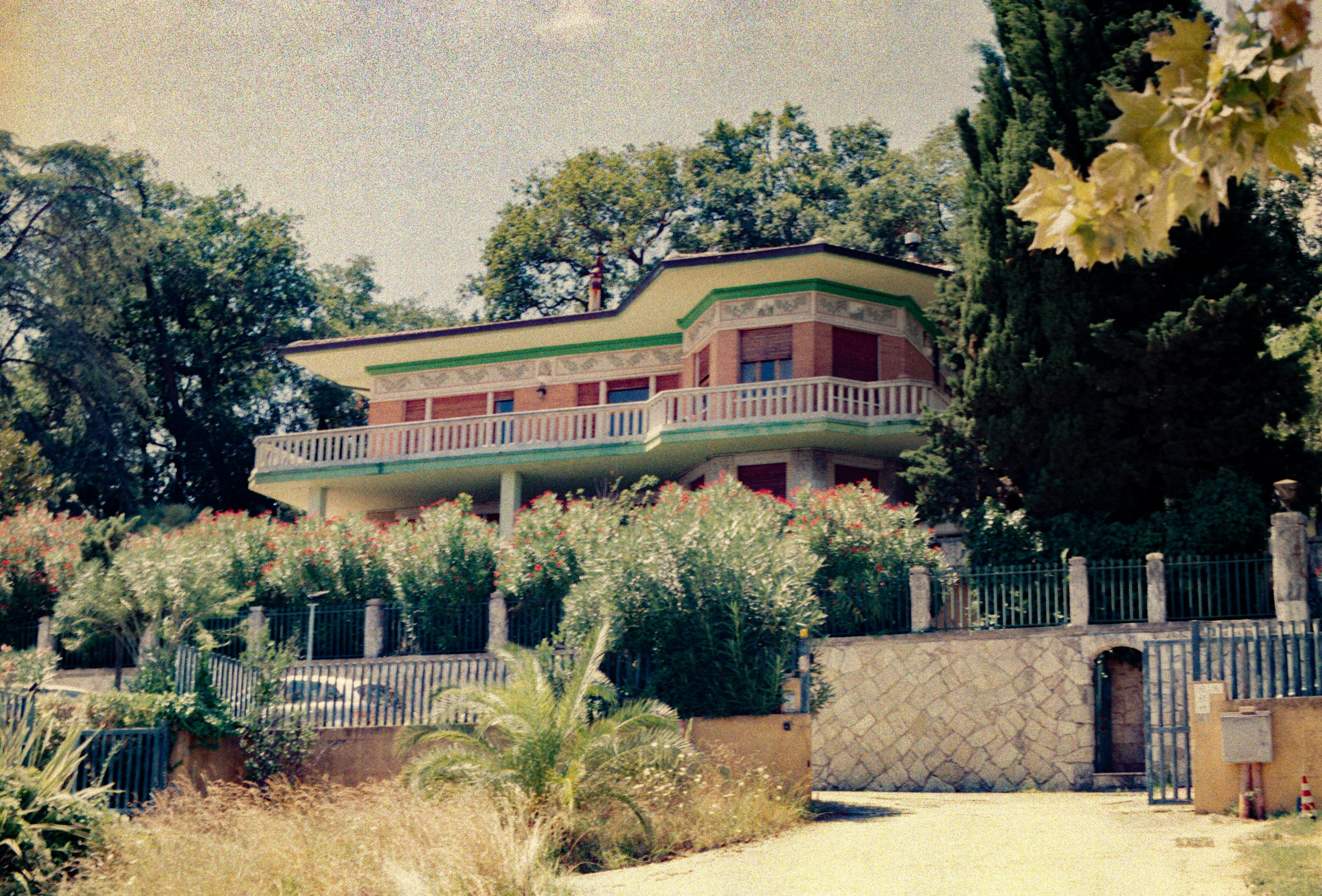 Modern house with balcony surrounded by greenery