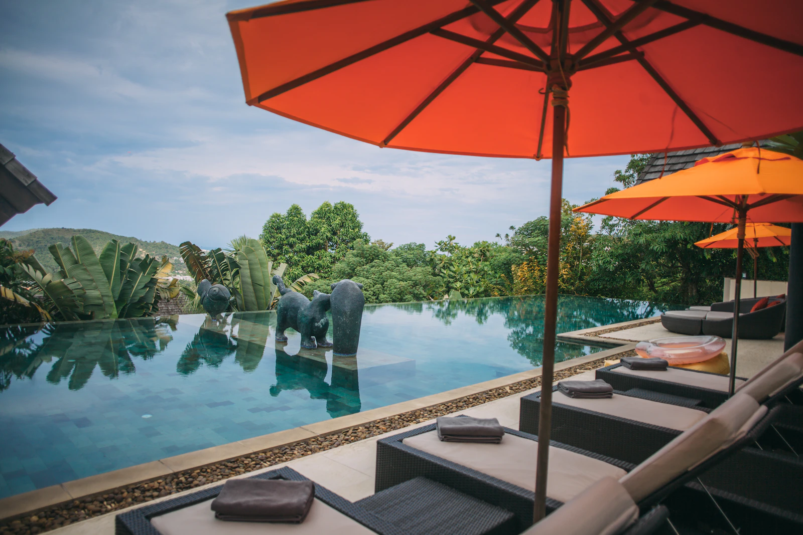 An infinity pool with loungers and parasols overlooking the landscape